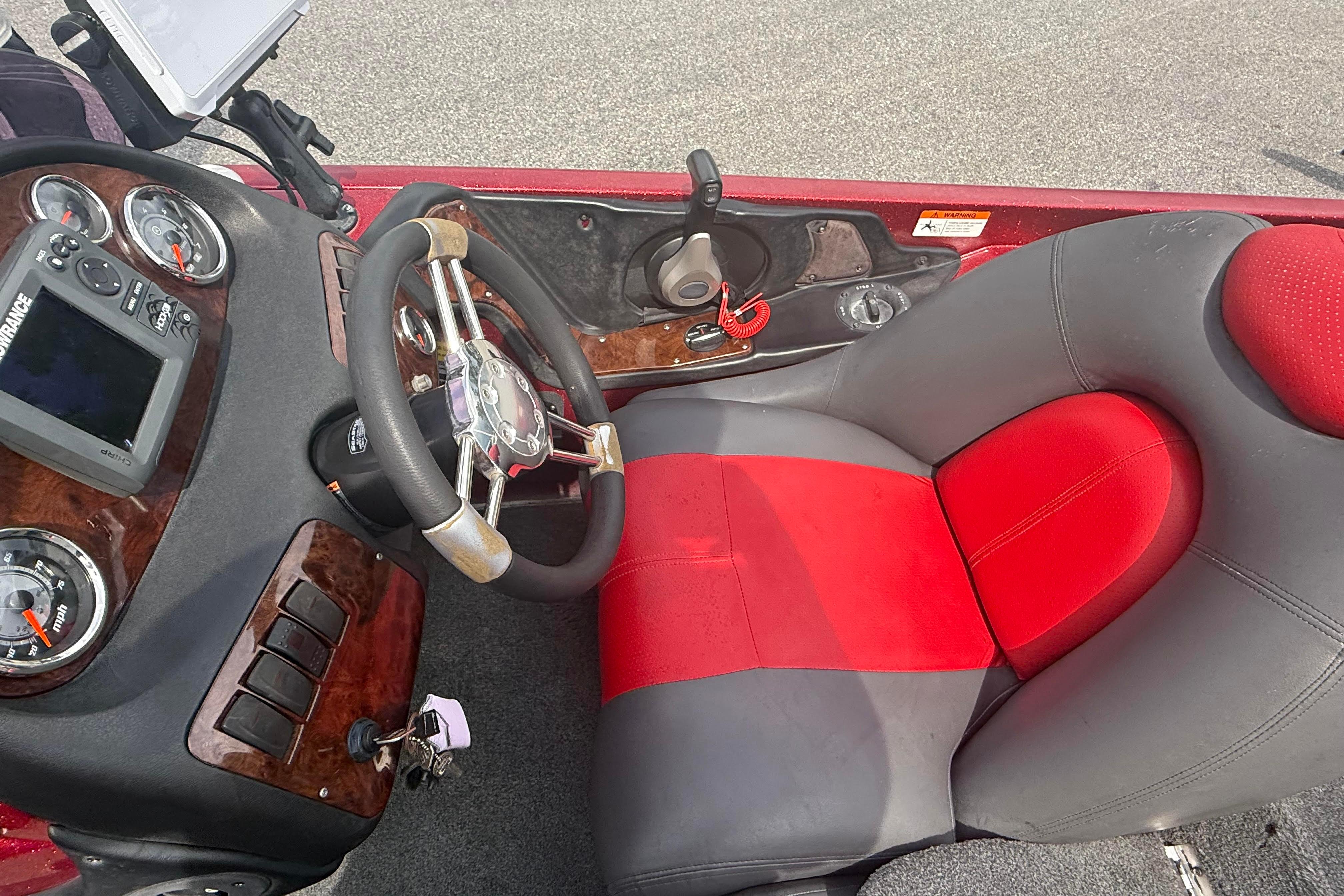 2007 Ranger 519 VX boat cockpit with steering wheel, gauges, and red-gray seat.