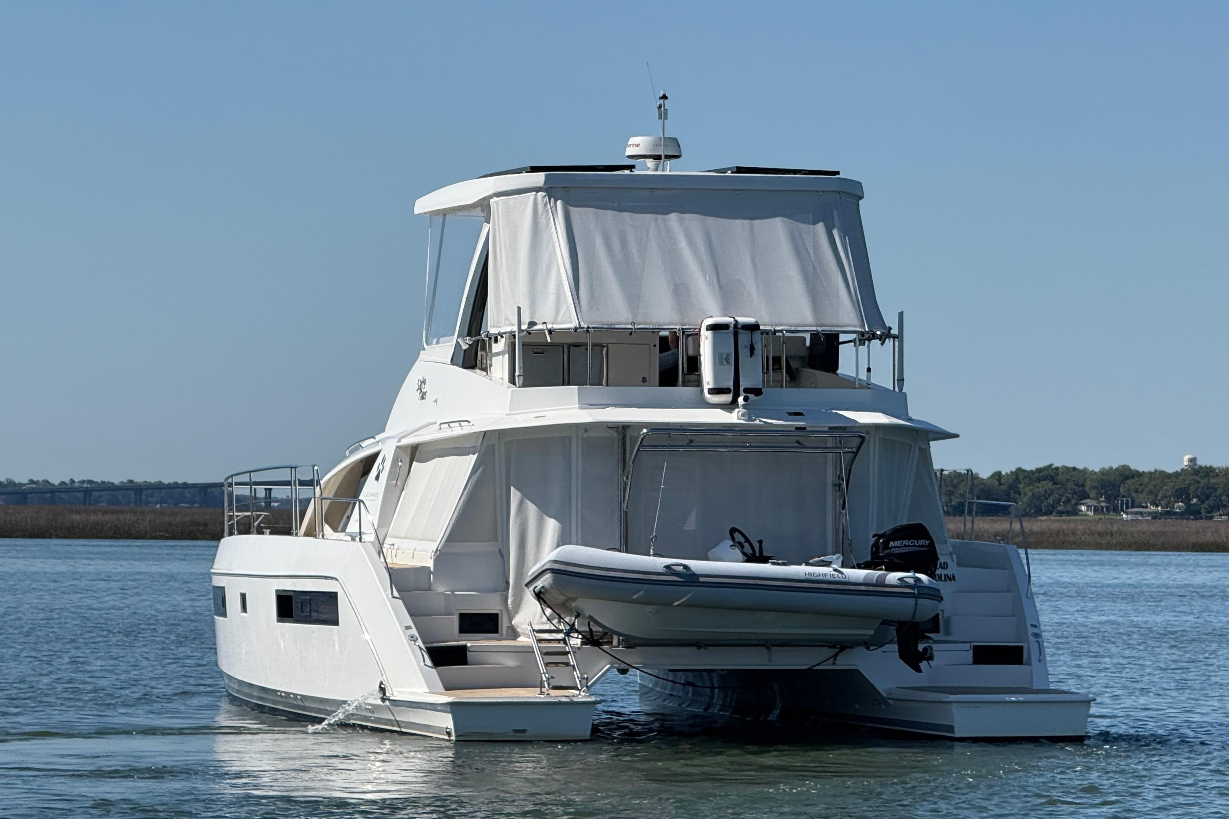 2021 Leopard 43 Powercat yacht on water, rear view with dinghy attached.