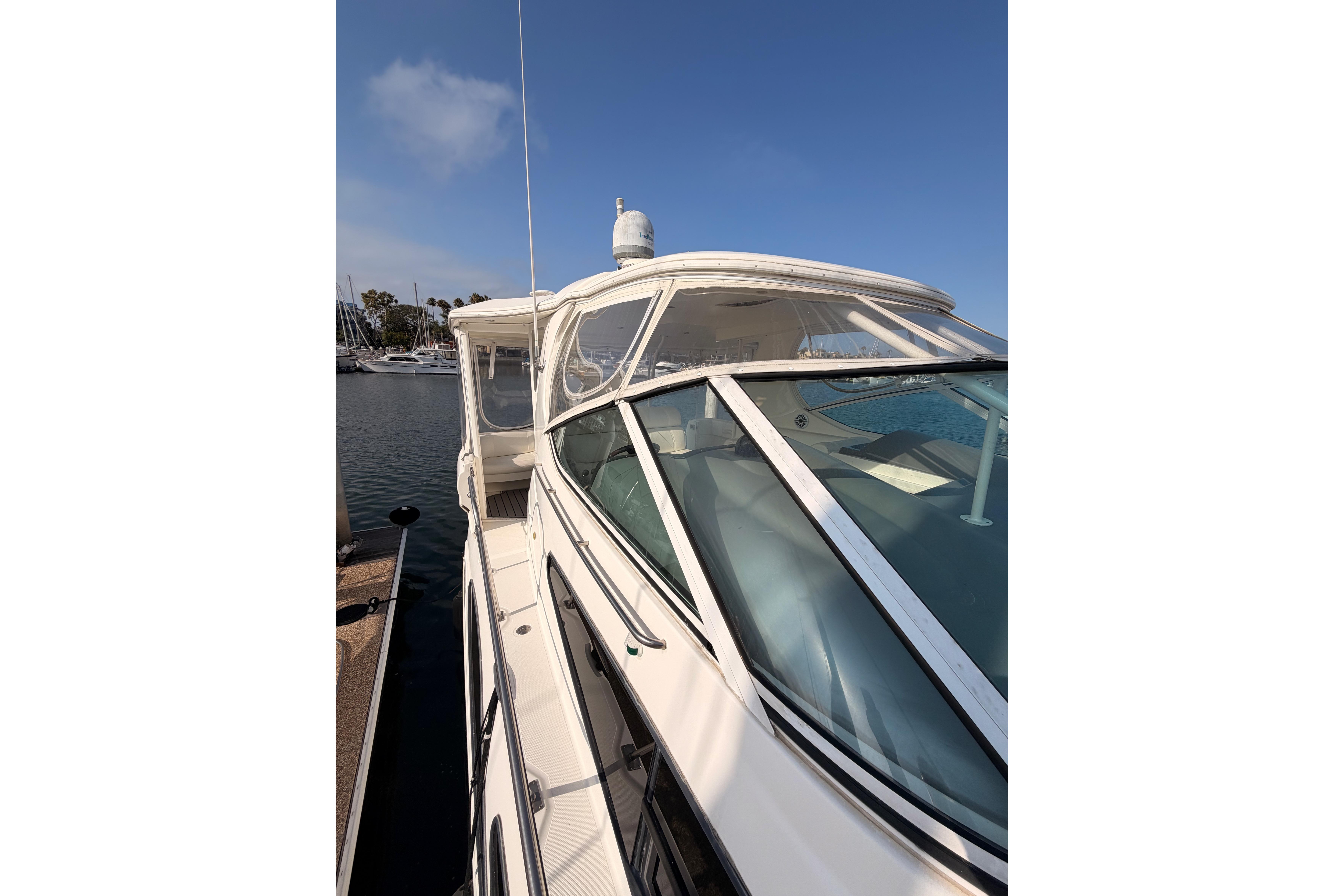 2005 Cruisers Yachts 405 Express Motoryacht docked at marina under clear blue sky.