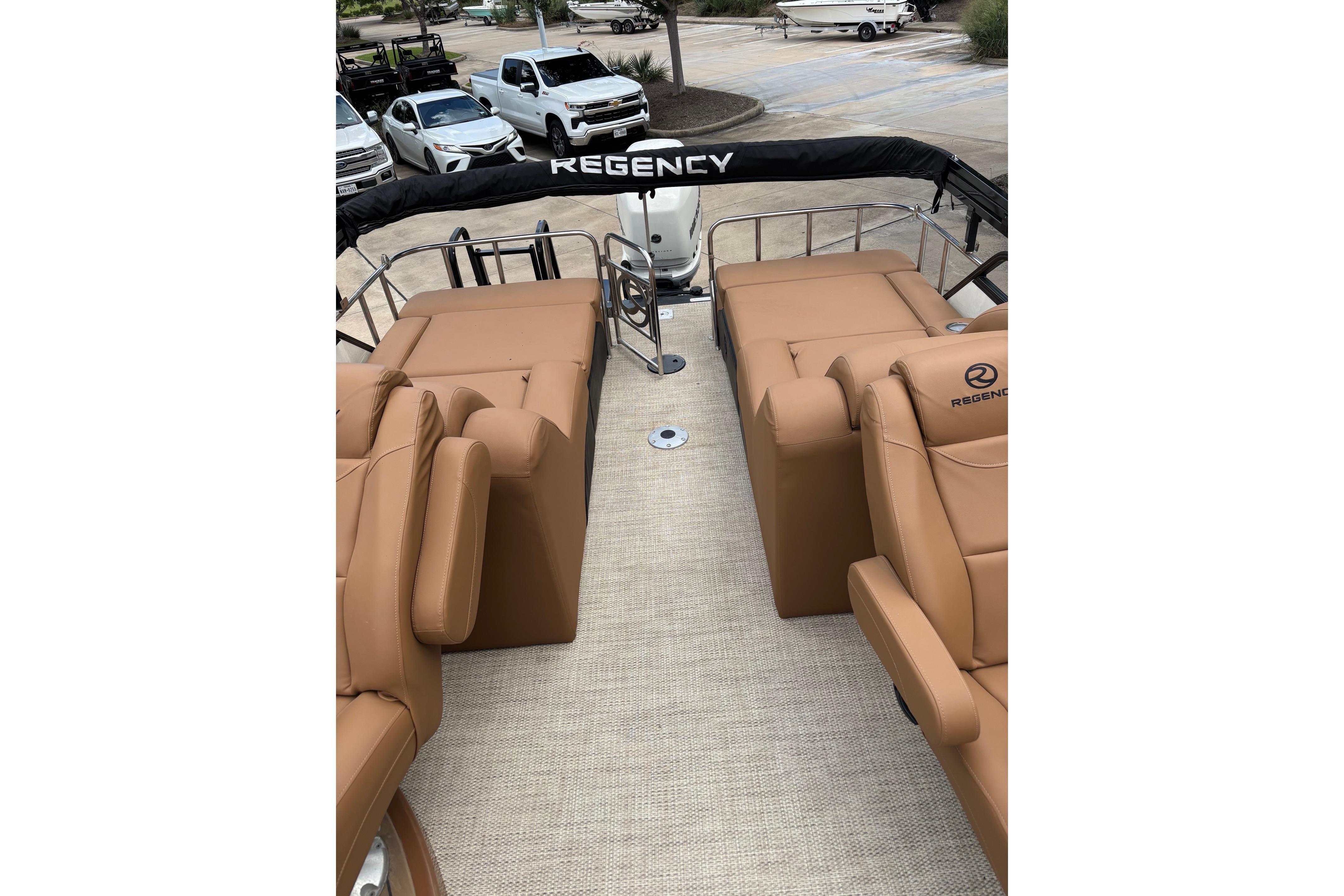 2018 Regency 254 LE3 Sport boat interior with tan seating and outdoor view.