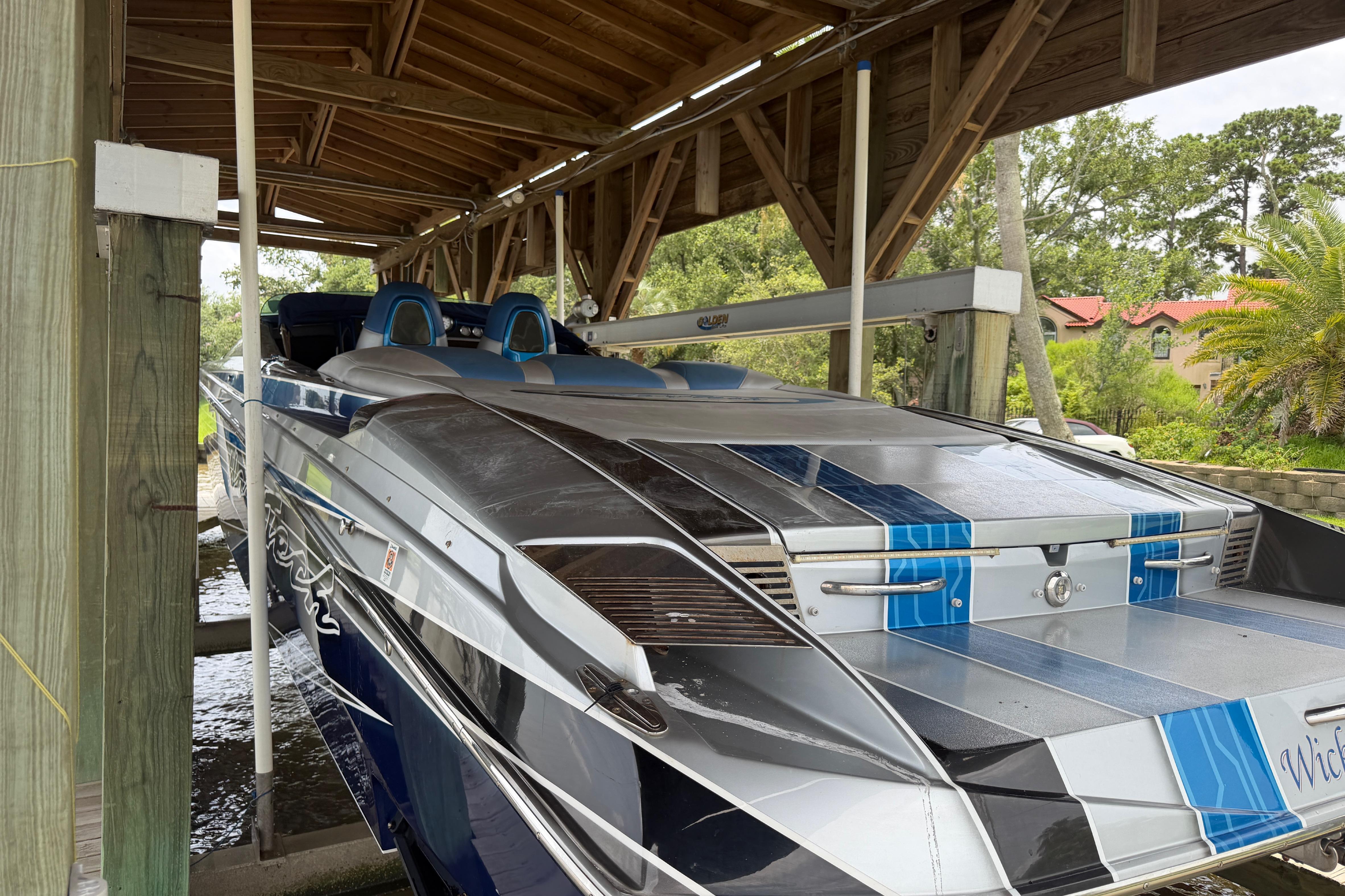 2013 Nor-Tech 477 SPX Vee Bottom boat in dock, featuring sleek design and blue accents.
