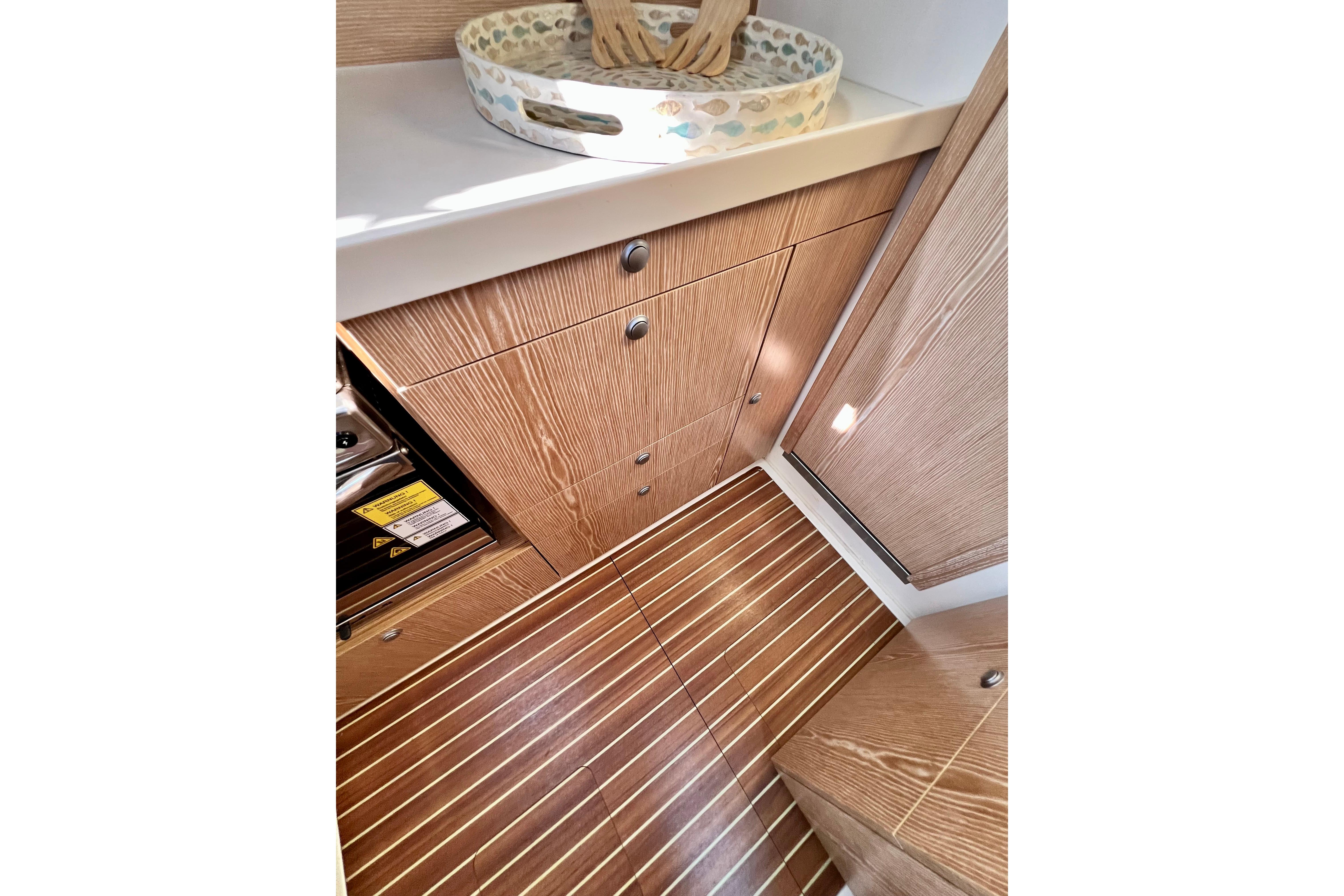 Interior of 2016 Hanse 455 yacht, featuring wooden cabinetry and striped flooring.