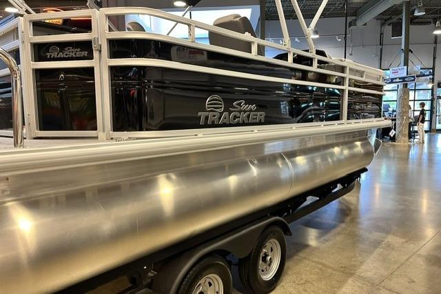 2026 Sun Tracker SportFish 20 DLX pontoon boat displayed indoors on a trailer.