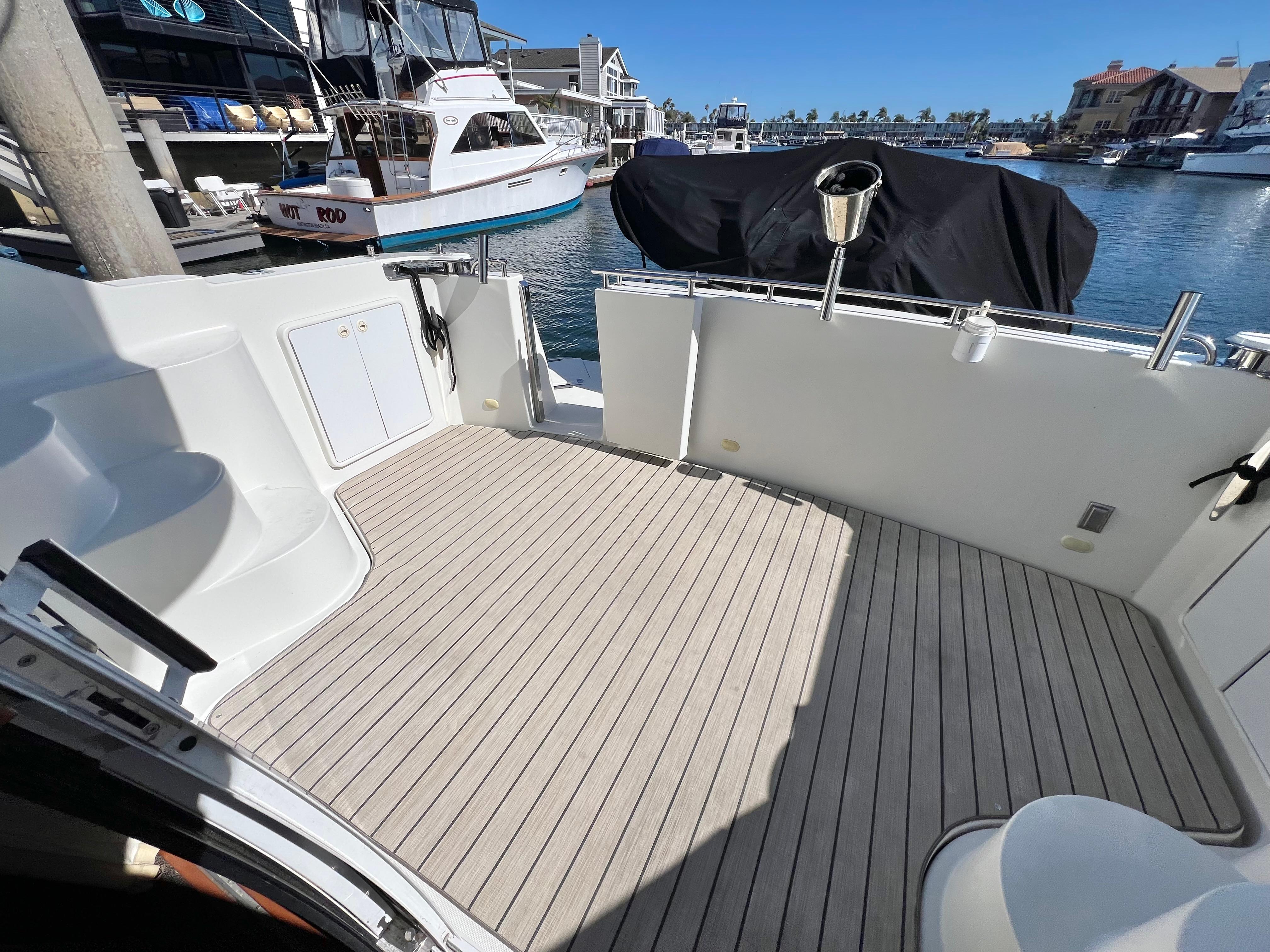 2004 Carver 420 Mariner boat deck with wood flooring, docked in a marina.