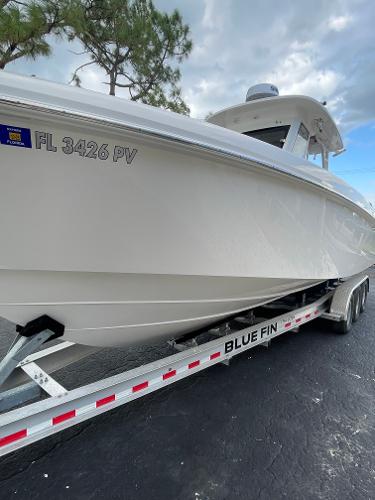 2014 Everglades 325 Center Console boat on Blue Fin trailer, parked outdoors.