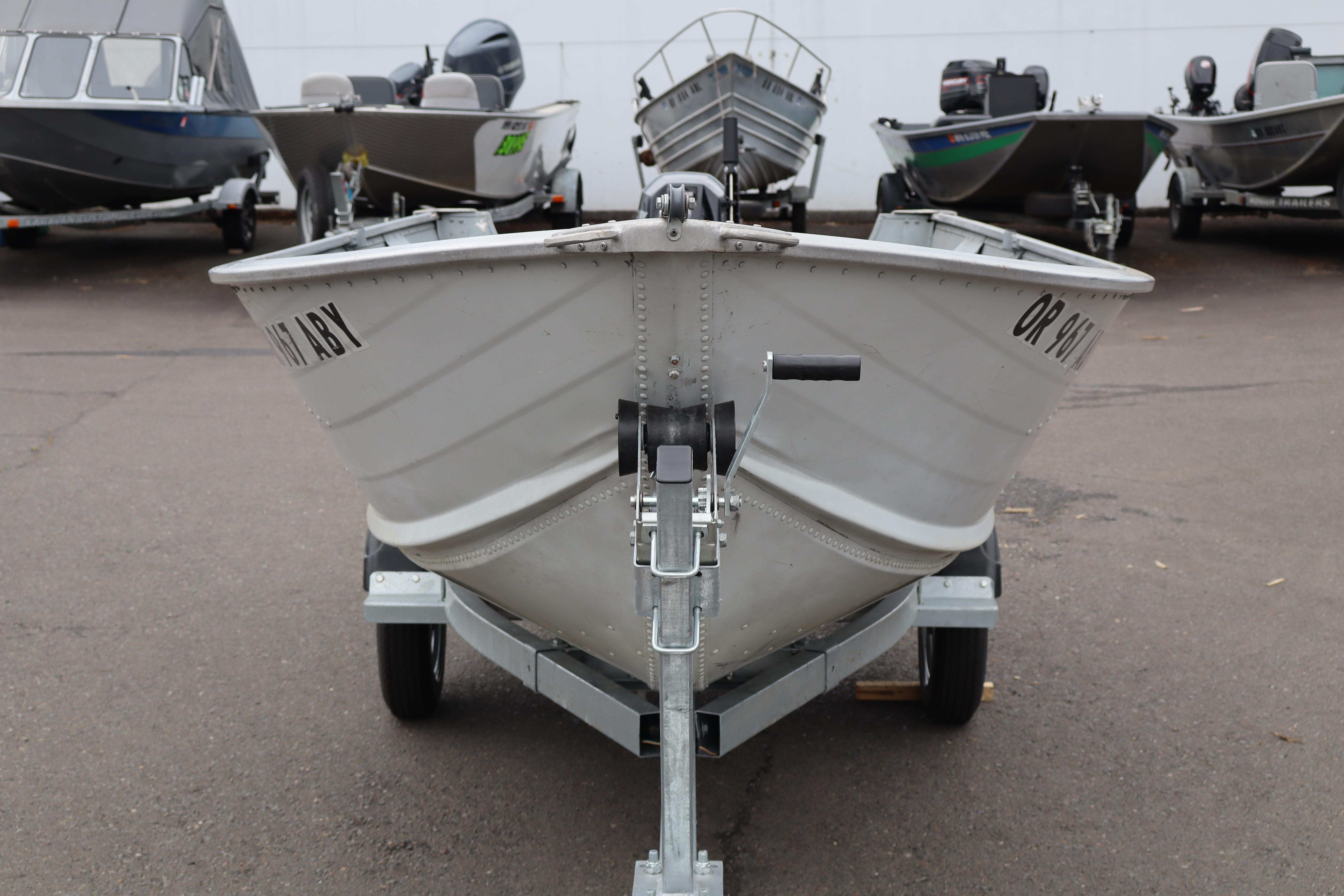 2003 Smoker Craft Alaskan 13 boat on trailer, parked among other boats.