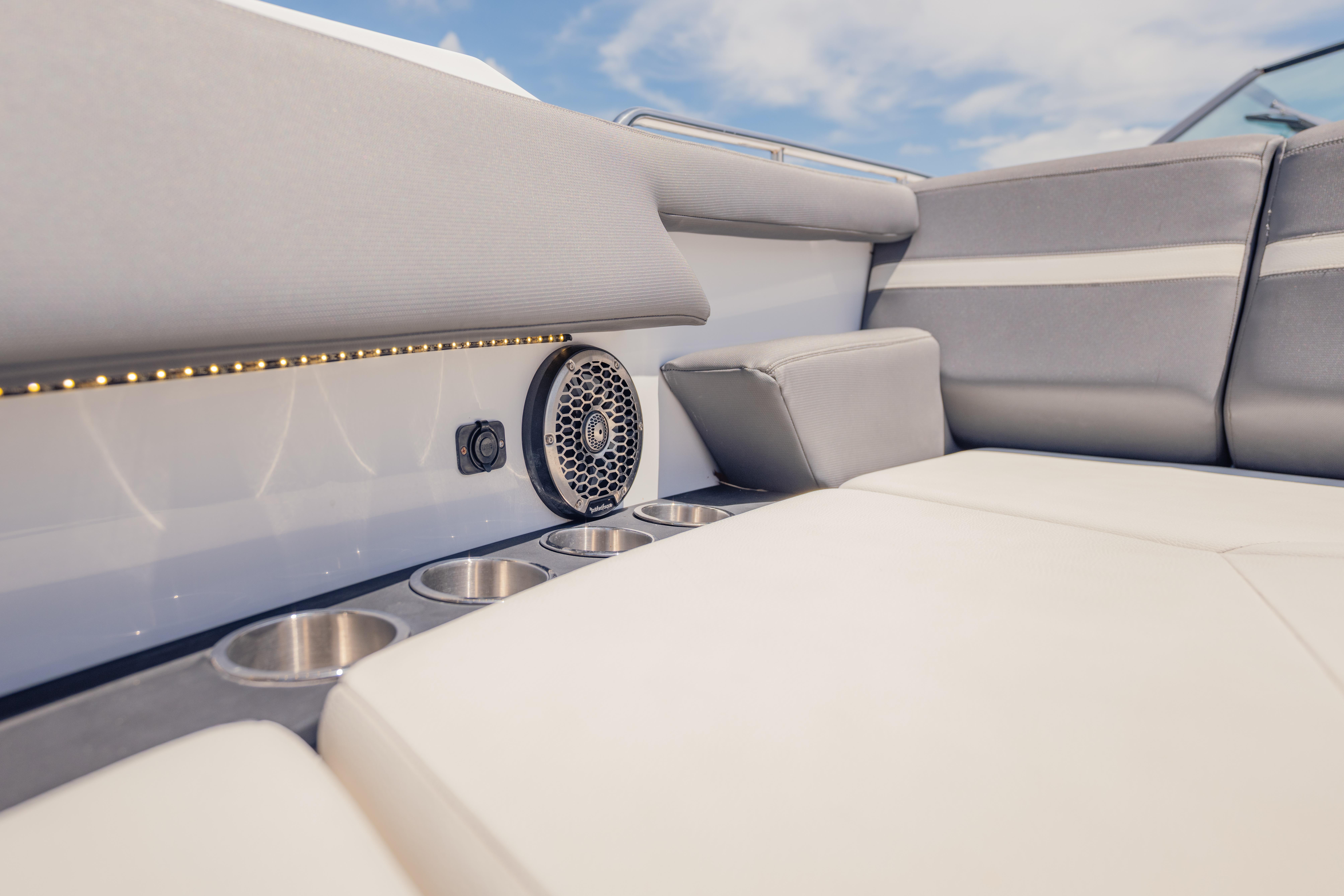 Luxurious seating area on 2021 Cruisers Yachts 38 GLS with cup holders and speaker.