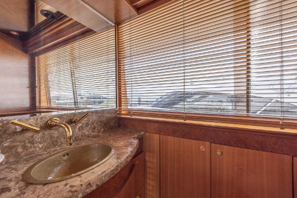 Luxurious bathroom interior of 2001 Grand Harbour 76 yacht with marble sink and wooden cabinetry.