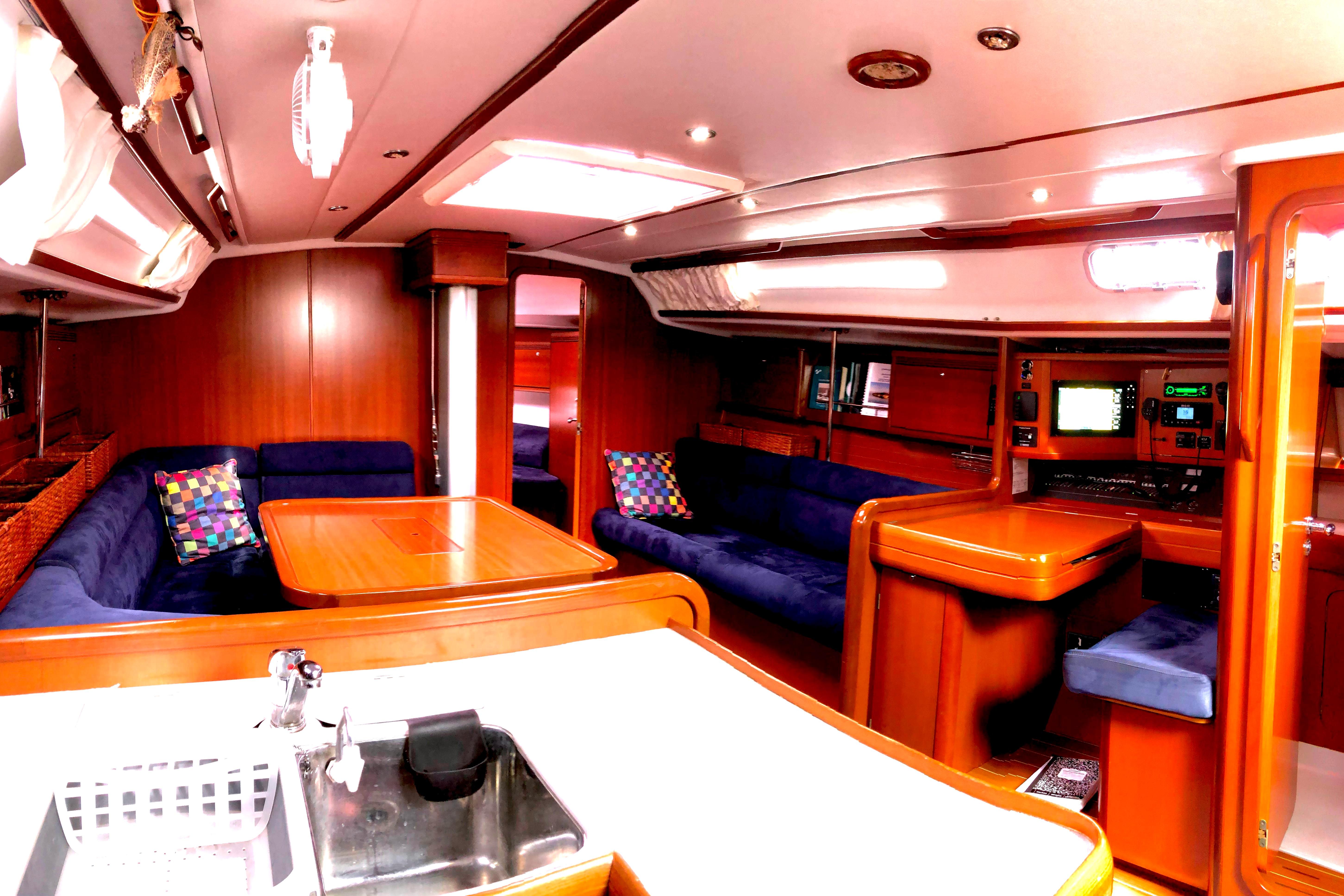 Luxurious interior of 2006 Grand Soleil 50 yacht with wood finish and blue seating.