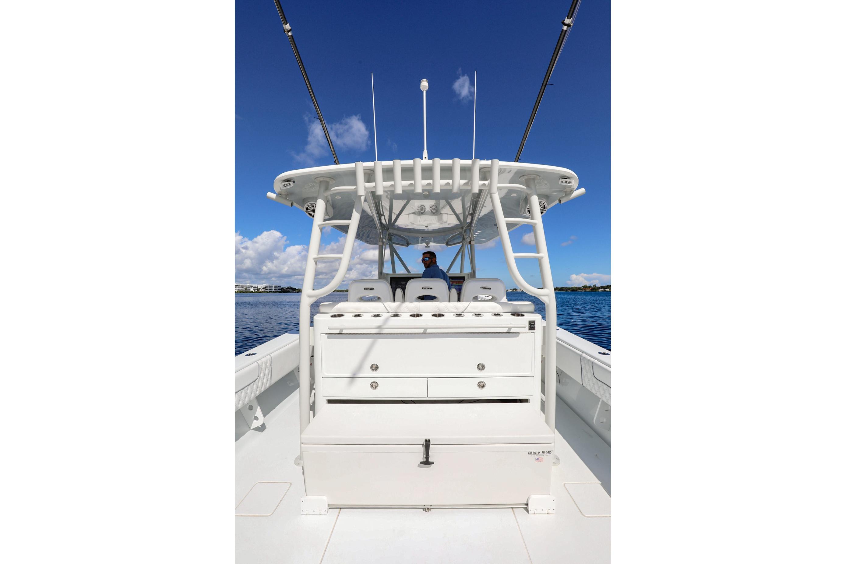 2023 Contender 44 ST boat with center console, white seating, and blue sky background.