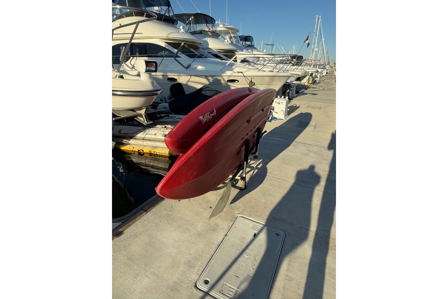 Red Maxum 3700 SCR boat docked at marina, surrounded by other vessels, sunny day.