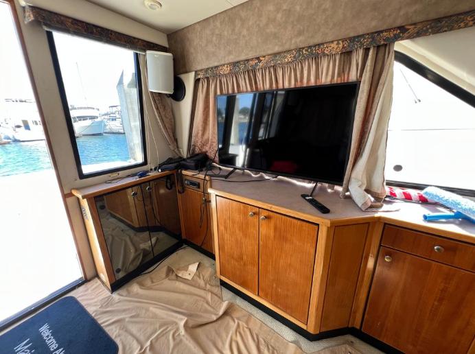 Interior of 1997 Bayliner 3788 Command Bridge Motoryacht with TV and wooden cabinetry.