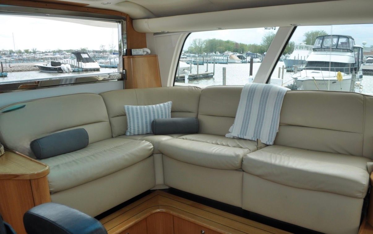 Interior of the 2005 Tiara Yachts 5200 Sovran with beige leather sofa and cushions.