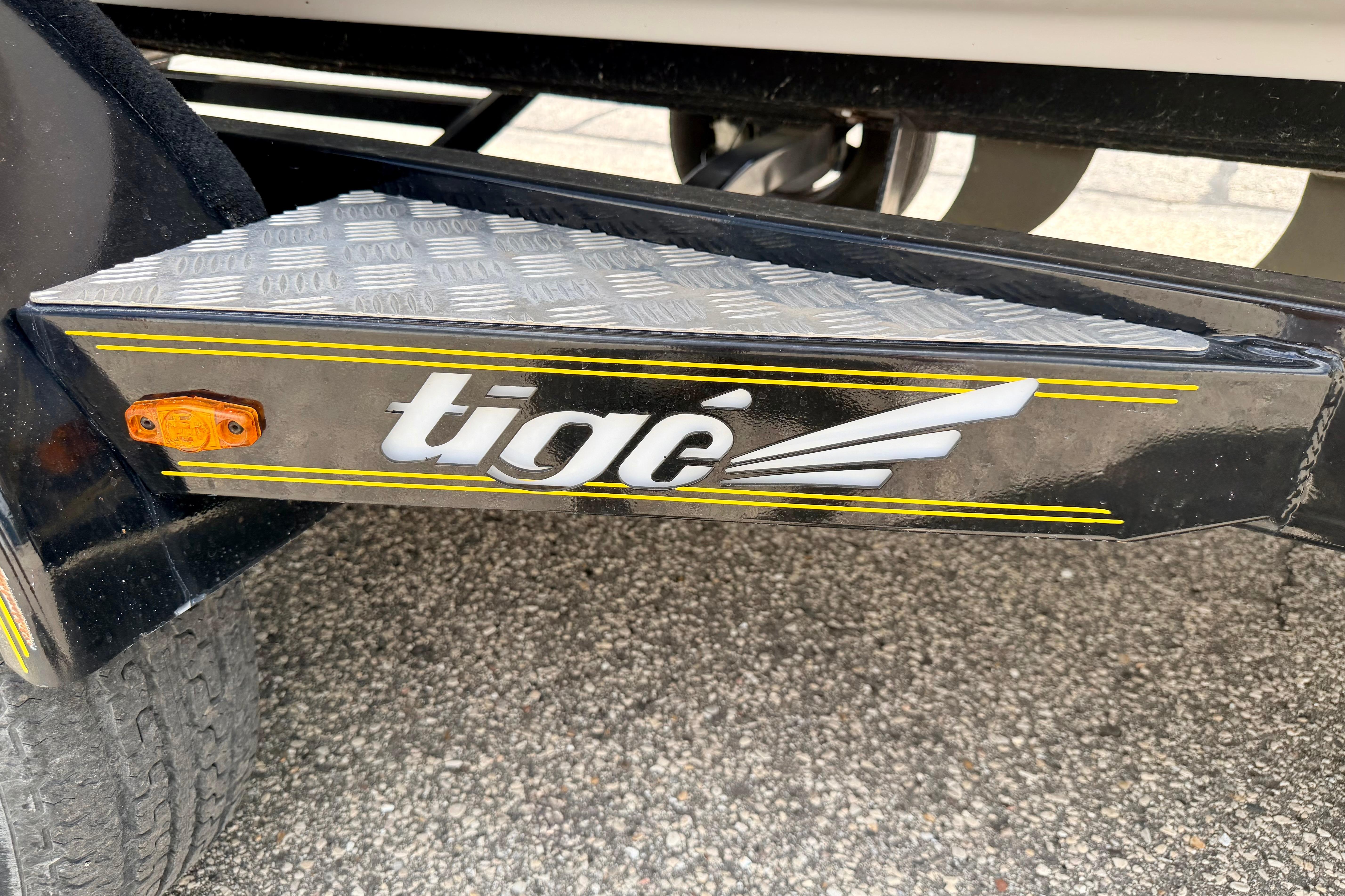 2014 Tigé R20 trailer step with logo and yellow accents on textured metal surface.