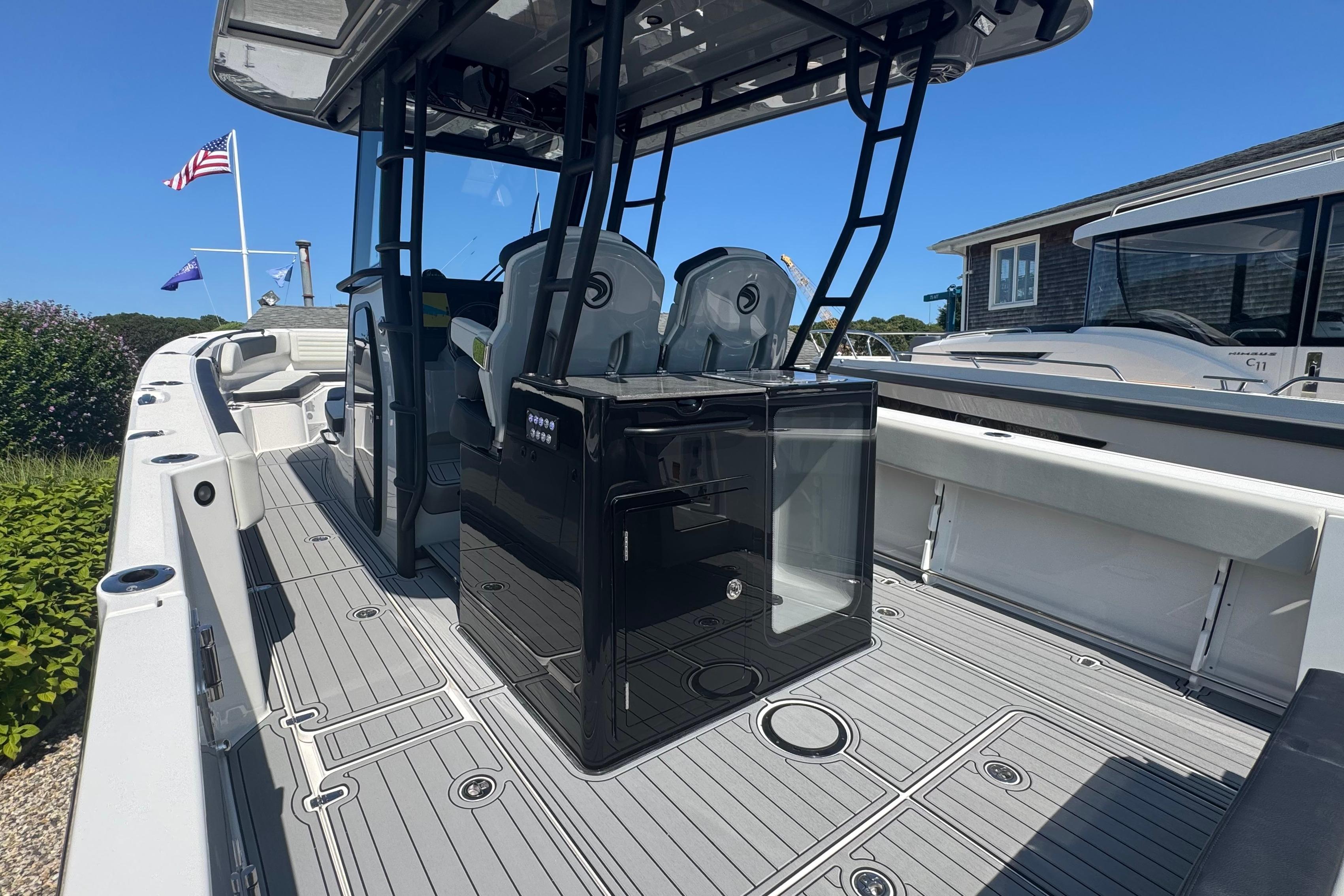 Edgewater 340CC 2025 boat interior with seating and console, docked under clear blue sky.