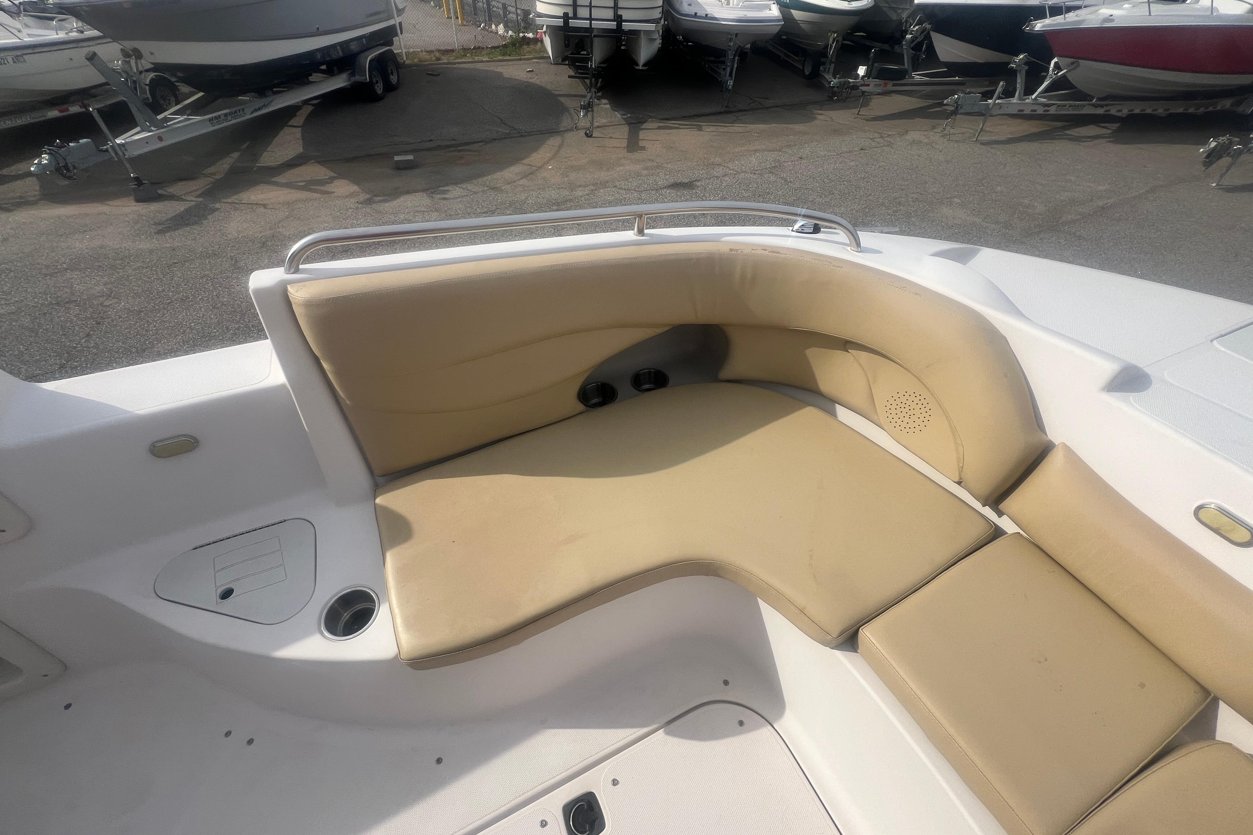 2002 Hurricane SunDeck 260 OB boat interior with beige seating and cup holders.
