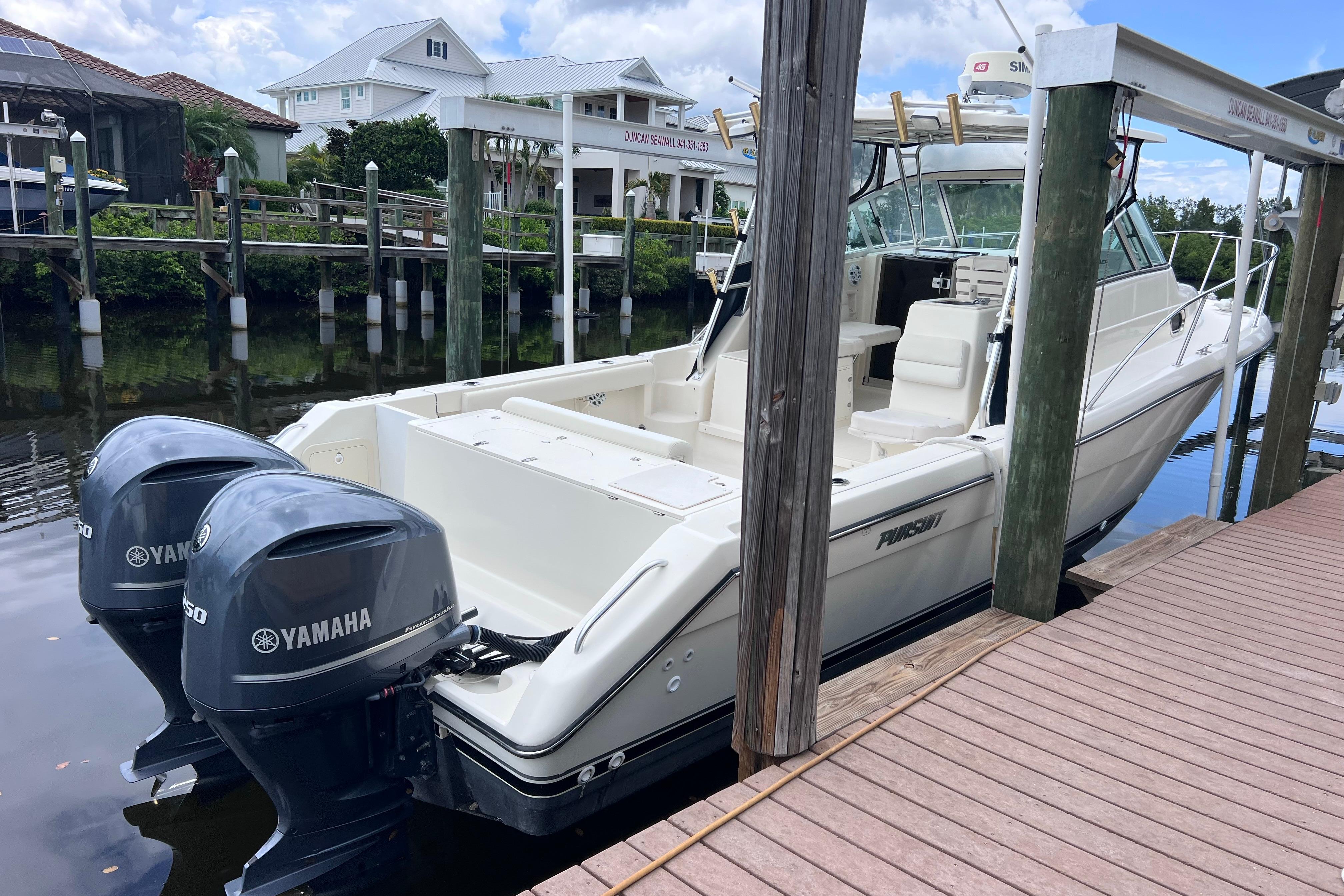 2005 Pursuit 3070 Offshore boat docked with twin Yamaha engines.