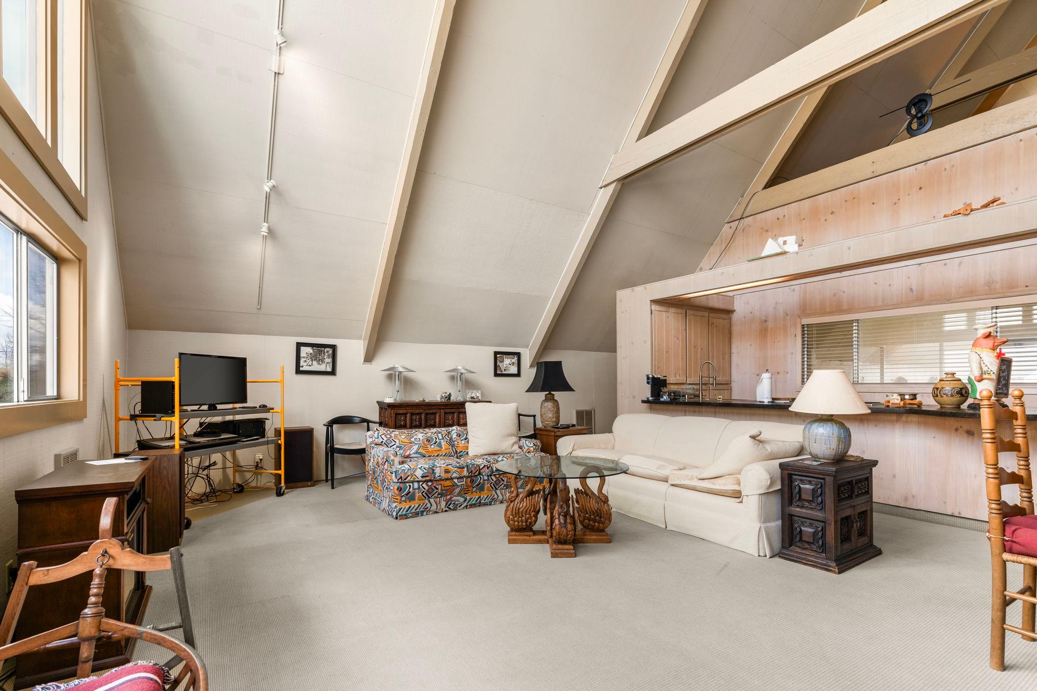 Spacious 1976 custom boathouse interior with vaulted ceilings, cozy seating, and modern decor.