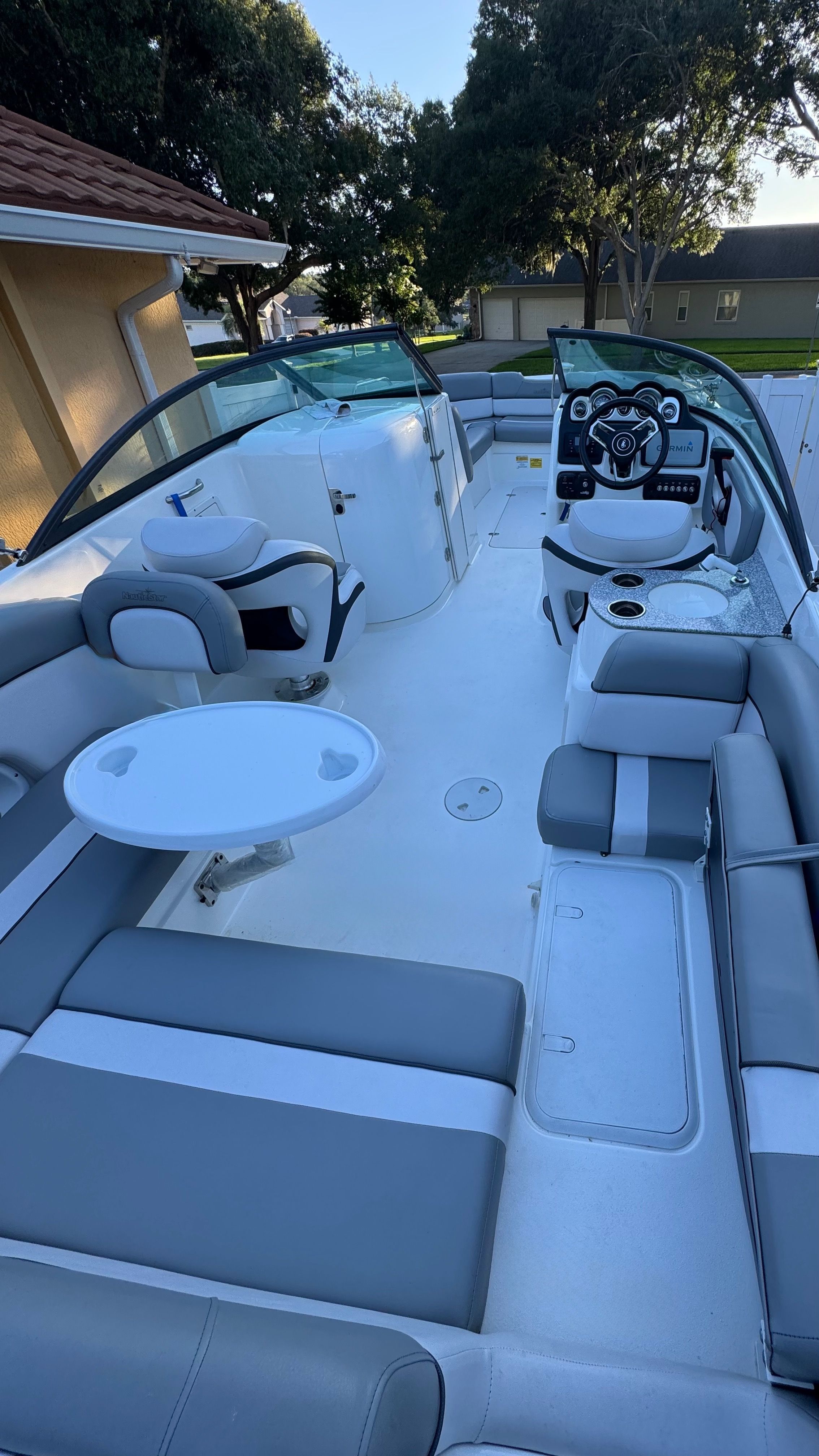 The image shows the interior of a 2022 NauticStar 243 DC boat with gray and white seating.