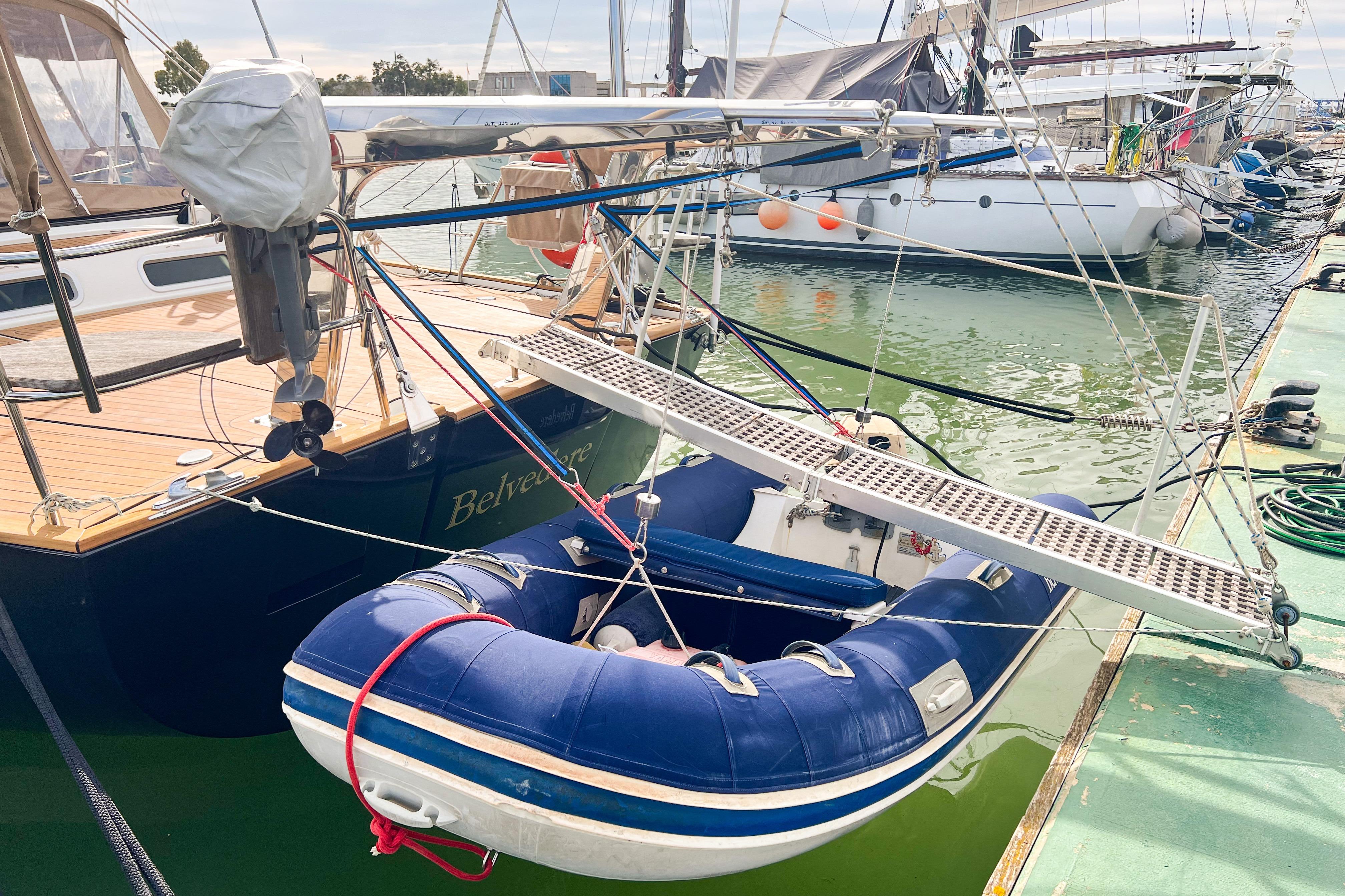 2004 Beneteau 57 yacht docked with inflatable dinghy attached at marina.