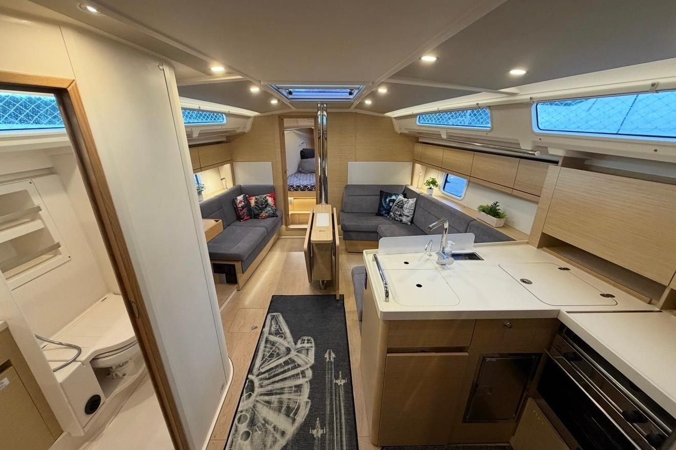 Luxurious interior of 2022 Hanse 418 yacht featuring modern kitchen and cozy seating area.