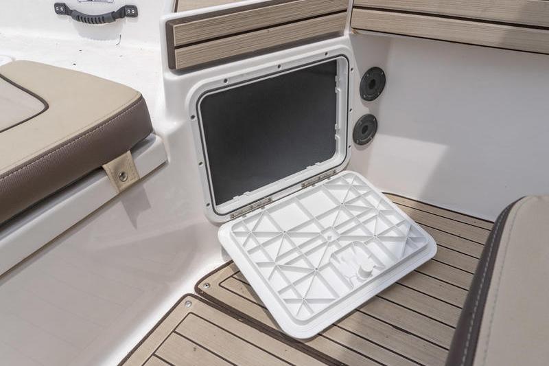 2023 Yamaha Boats 195 FSH Sport storage compartment with open hatch and cushioned seating.