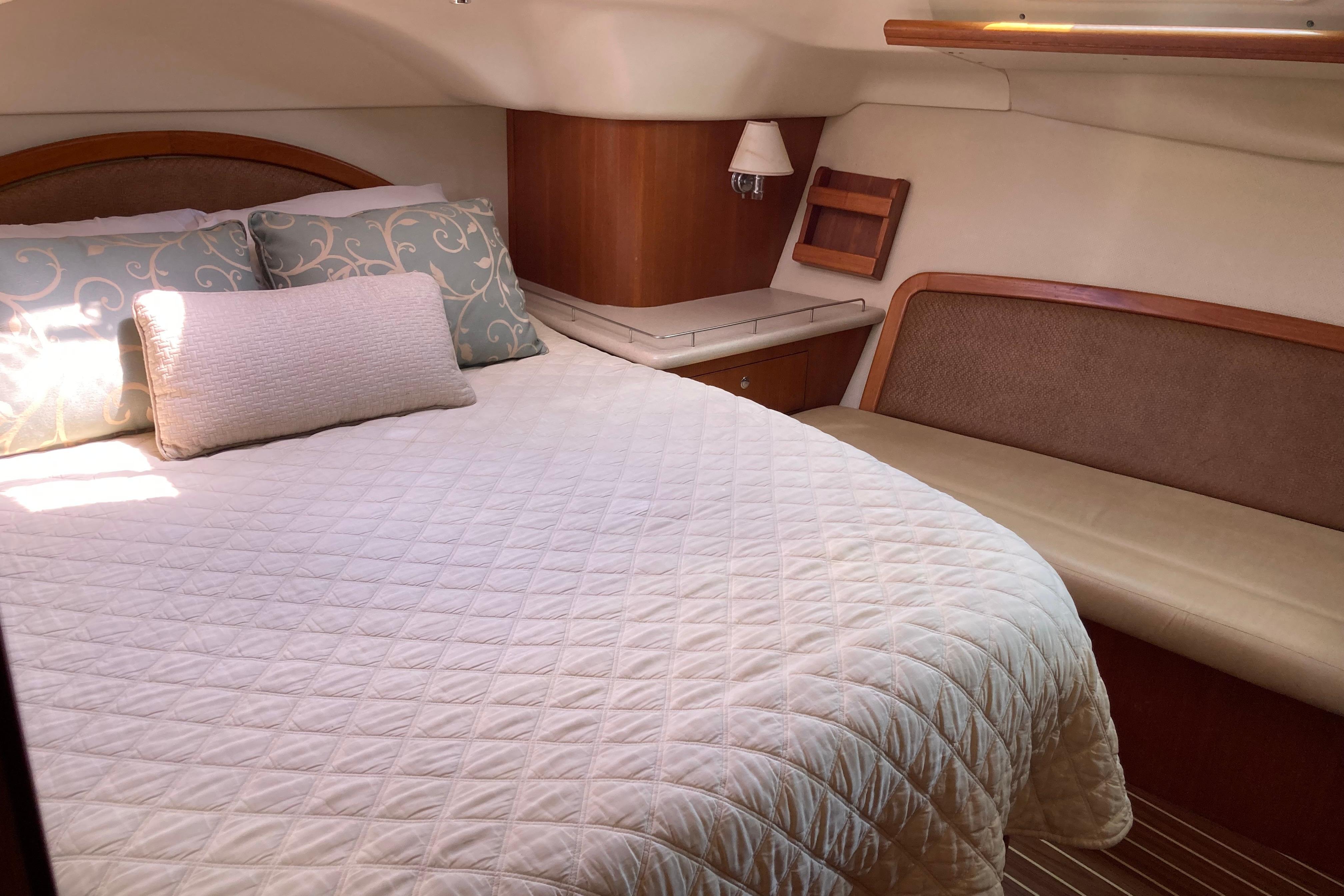 Luxurious cabin interior of 2006 Hunter 45 CC yacht with cozy bedding and seating.