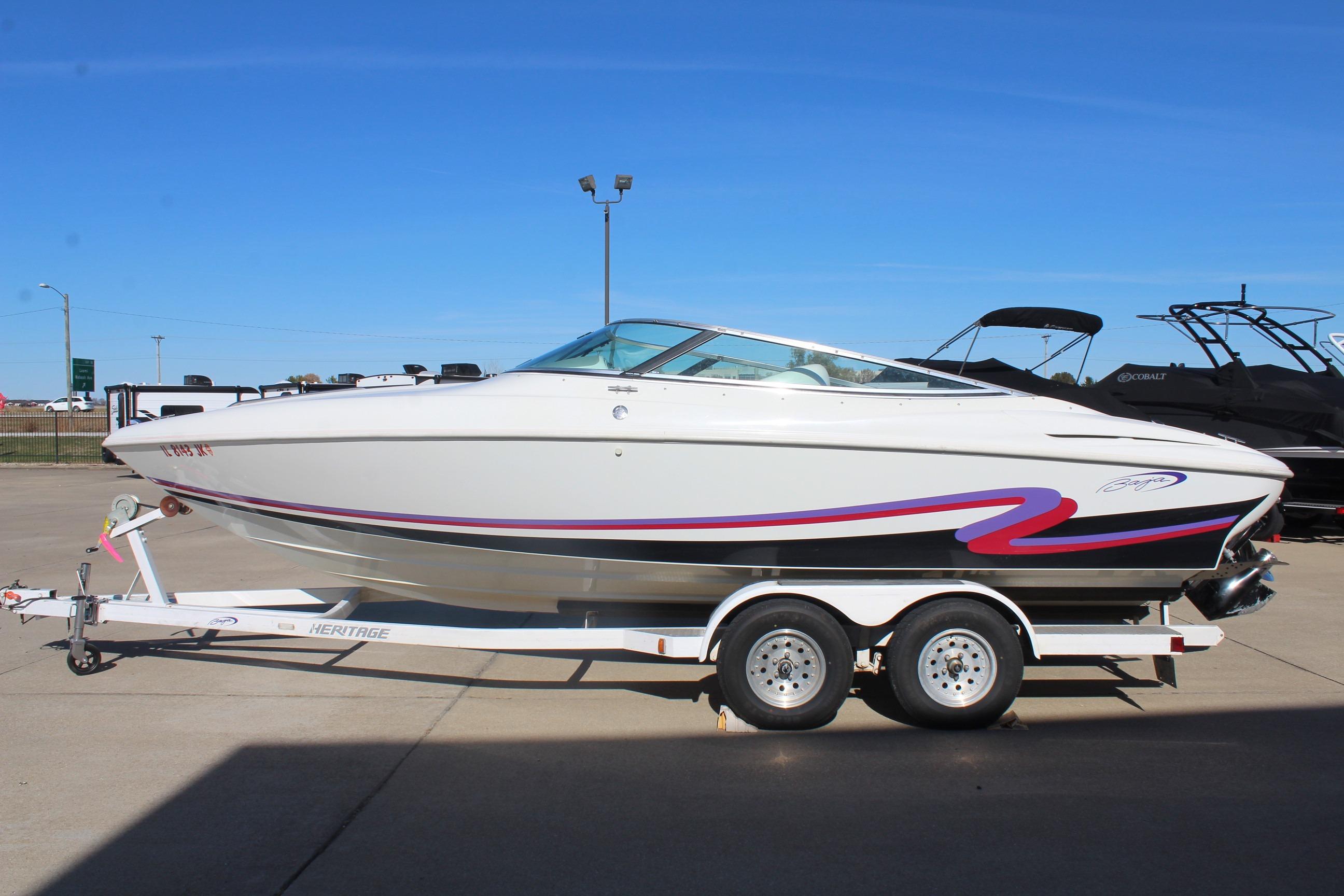 1996 Baja 232 speedboat on trailer, white with red and purple accents, parked outdoors.
