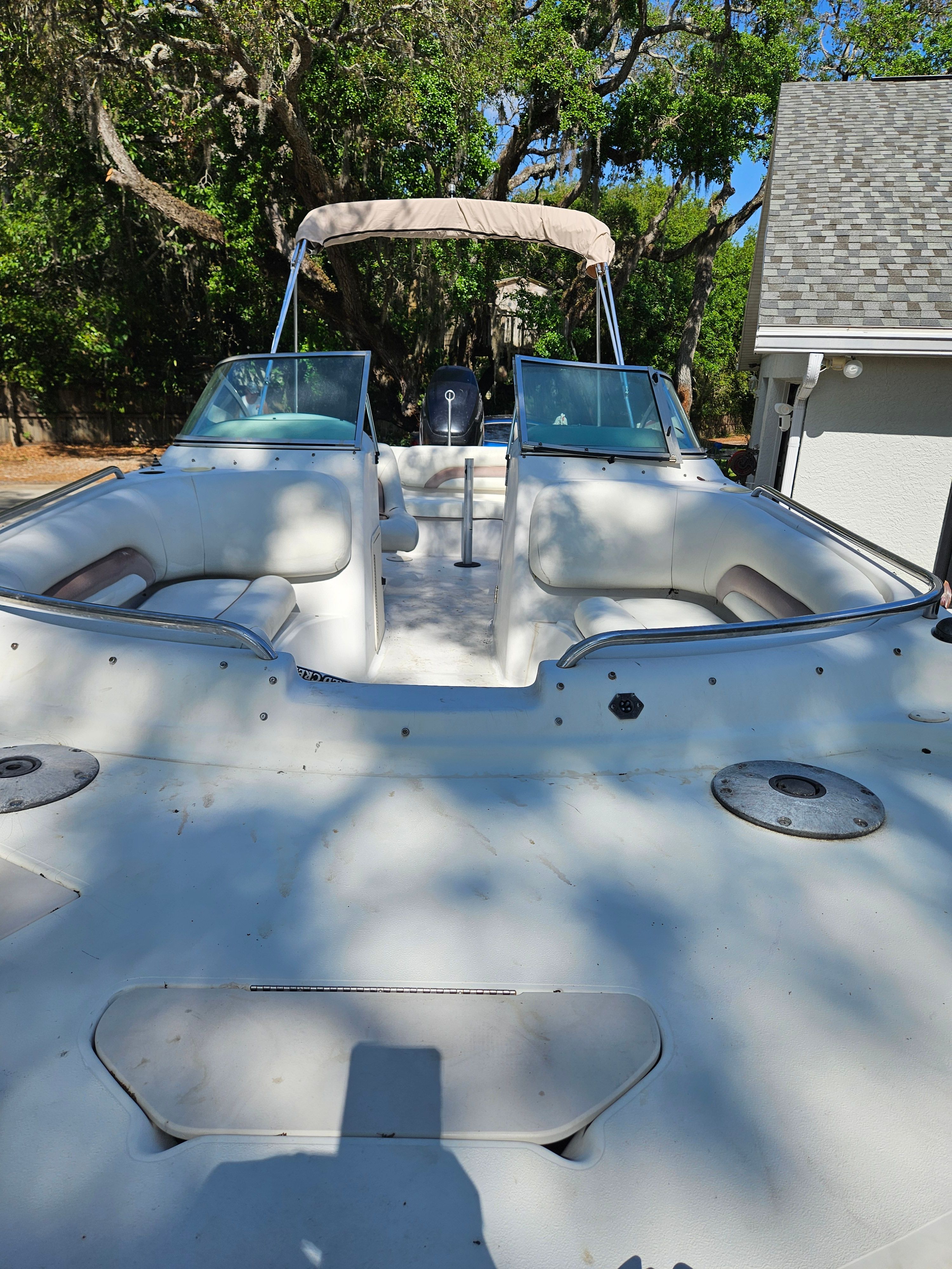 2001 Hurricane 237 with open deck and seating area, parked in a green setting.