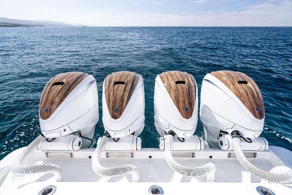 Four powerful outboard motors on a 2020 HCB 53 Sueños boat, ocean backdrop.