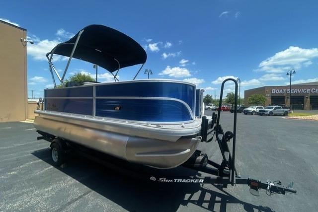 2026 Sun Tracker Party Barge 18 DLX pontoon boat on trailer, parked outdoors.