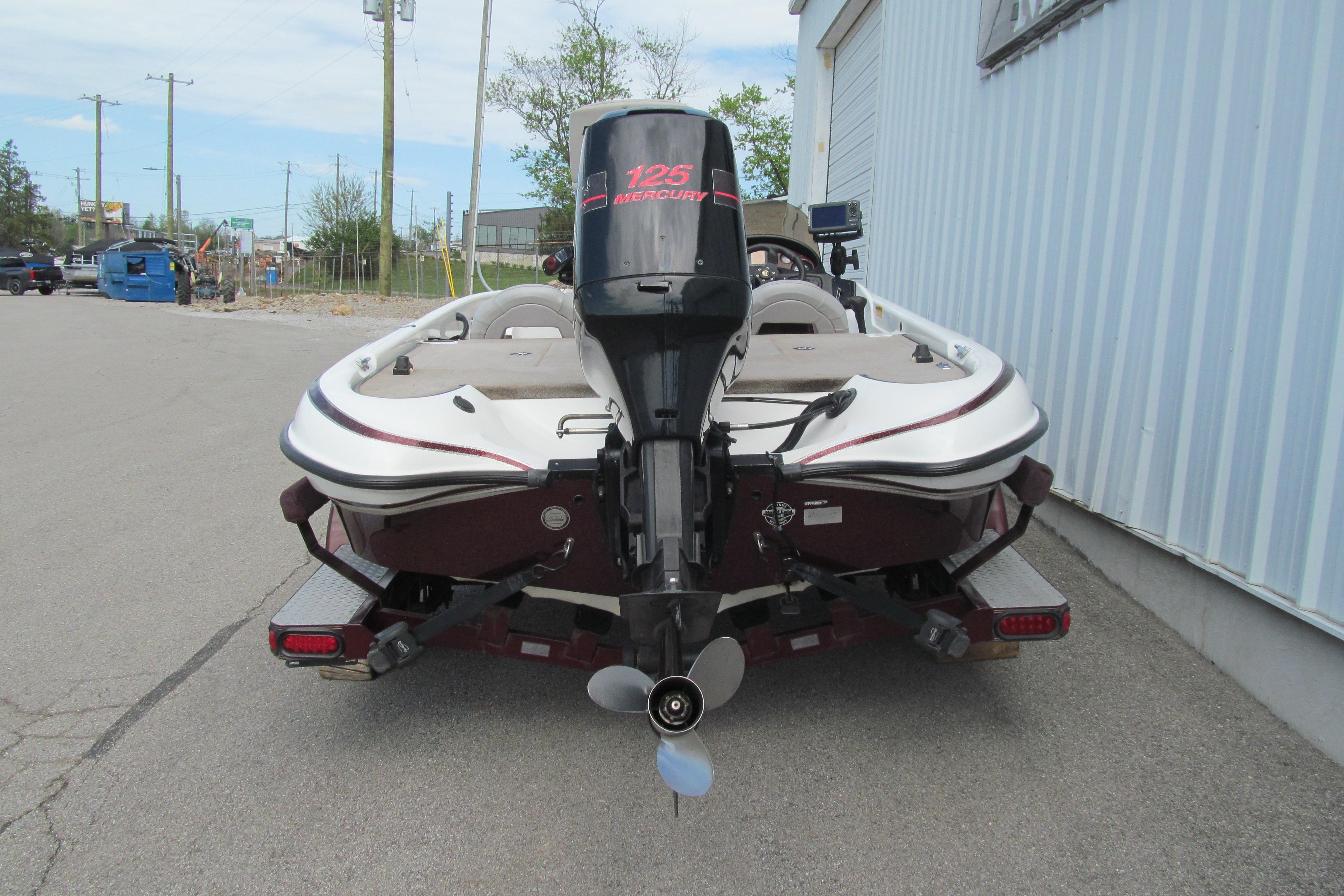 2002 Triton Tr-176 SC boat with Mercury 125 outboard motor, parked outdoors.
