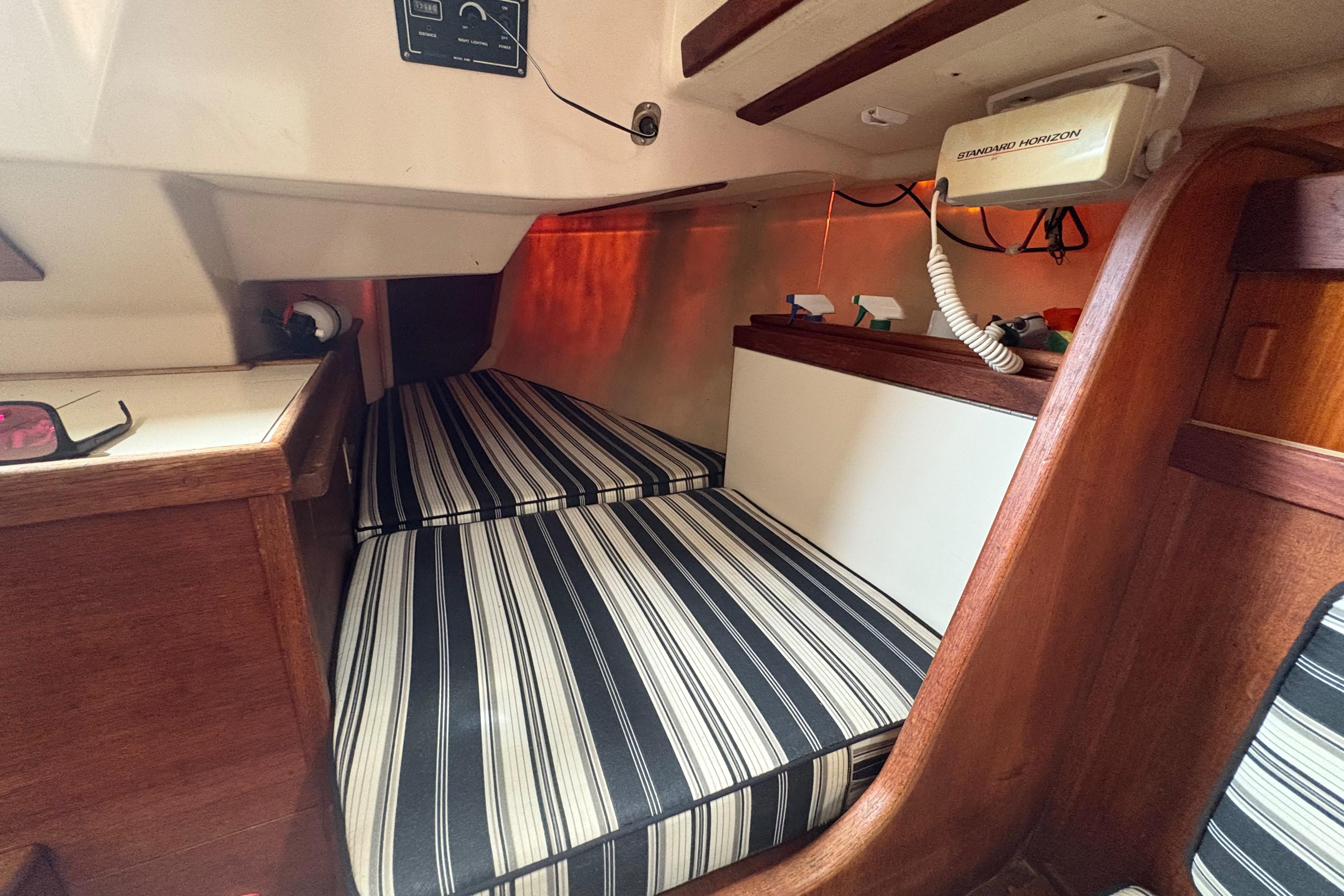 Interior cabin of 1981 Sabre 31 sailboat with striped cushions and wooden accents.