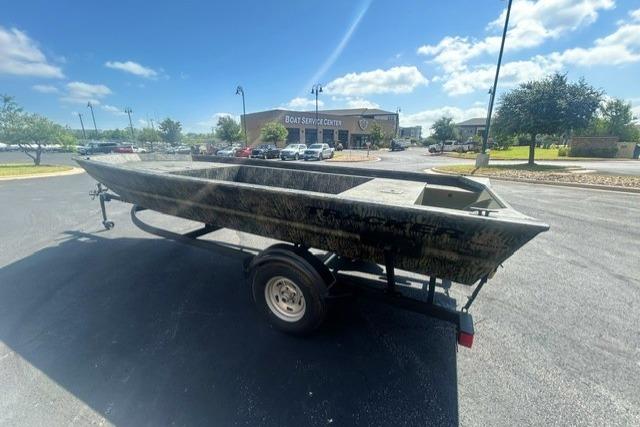 2026 Tracker Grizzly 1754 Utility boat on trailer in parking lot.