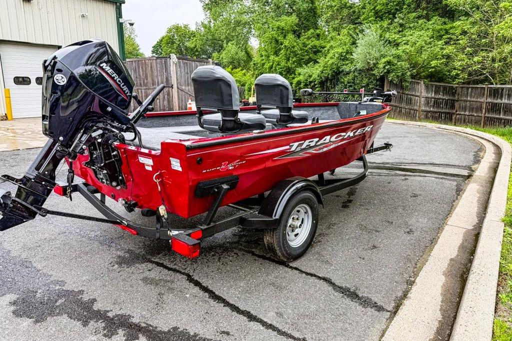 2025 Tracker Super Guide V-16 T boat with Mercury engine, parked outdoors.