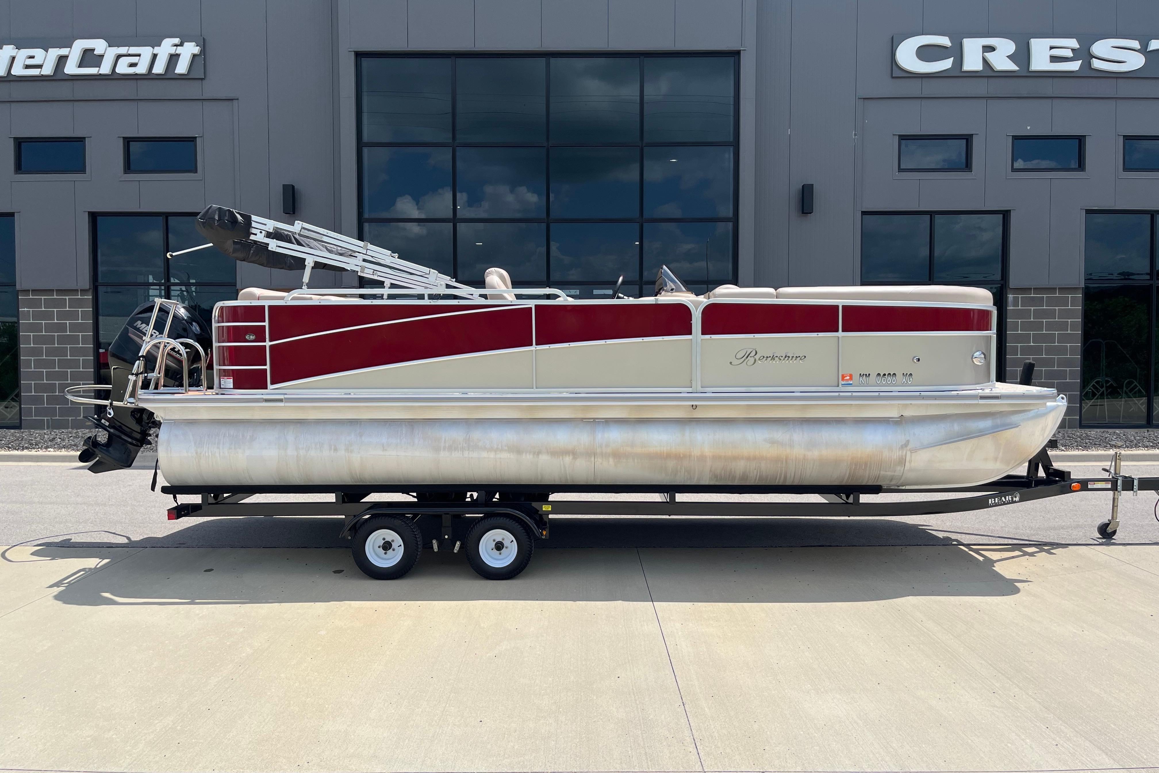 2013 Berkshire 230CL CTS pontoon boat on trailer, parked outside dealership.