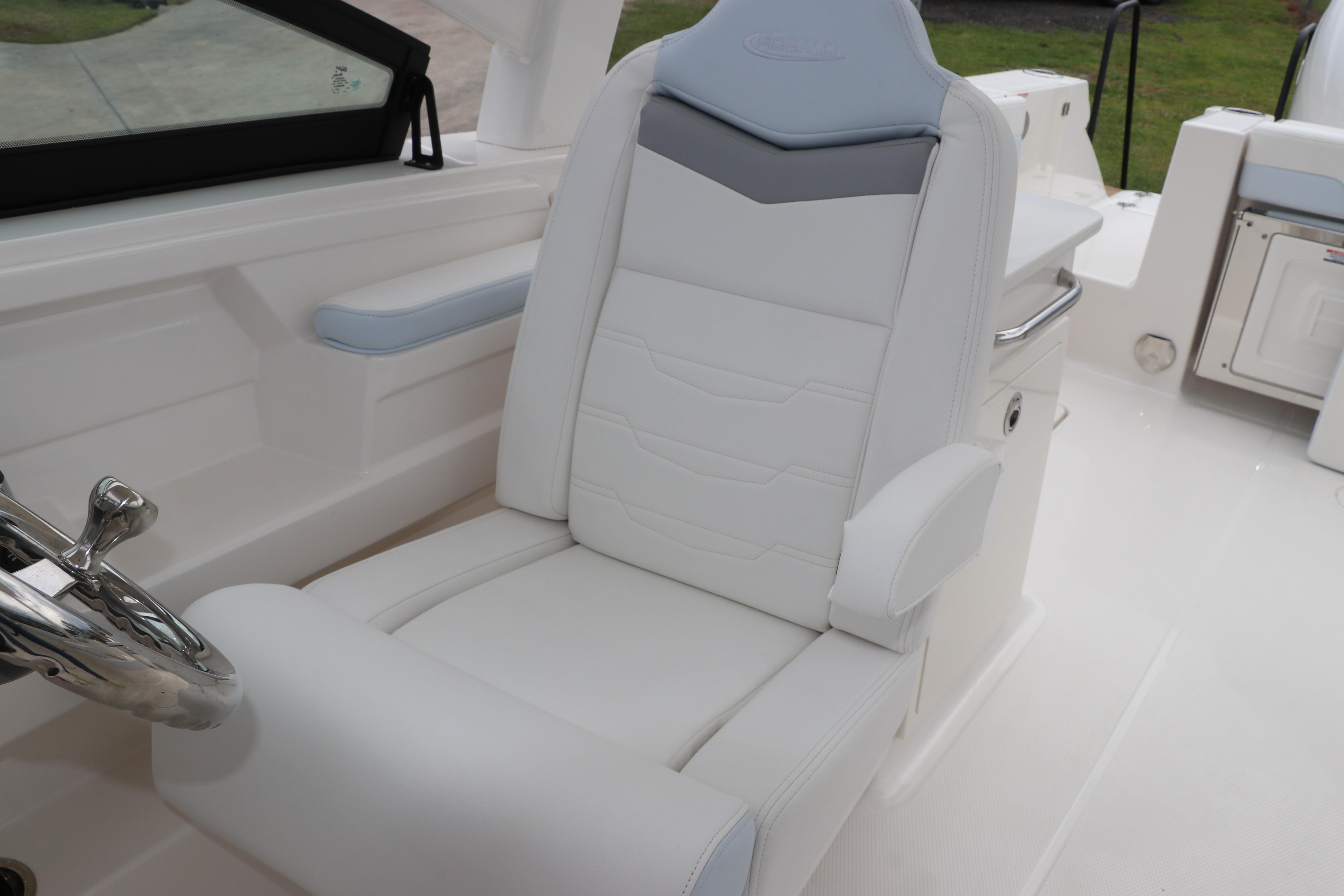 2026 Robalo R257 Dual Console boat seat with steering wheel, featuring white and gray upholstery.