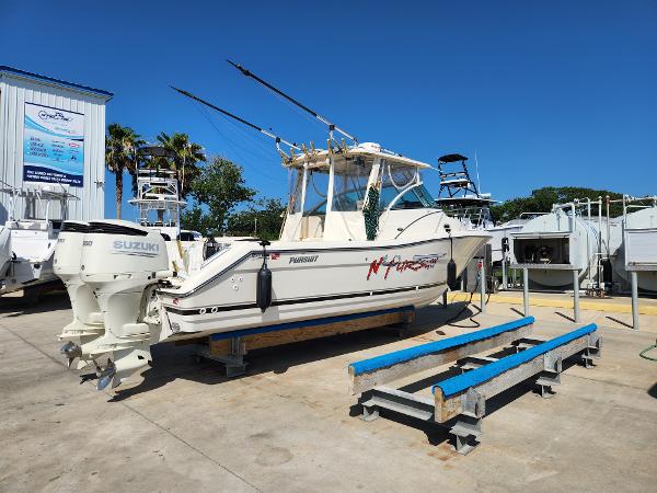 2005 Pursuit 3070 Offshore Center Console boat with Suzuki engines on a trailer.