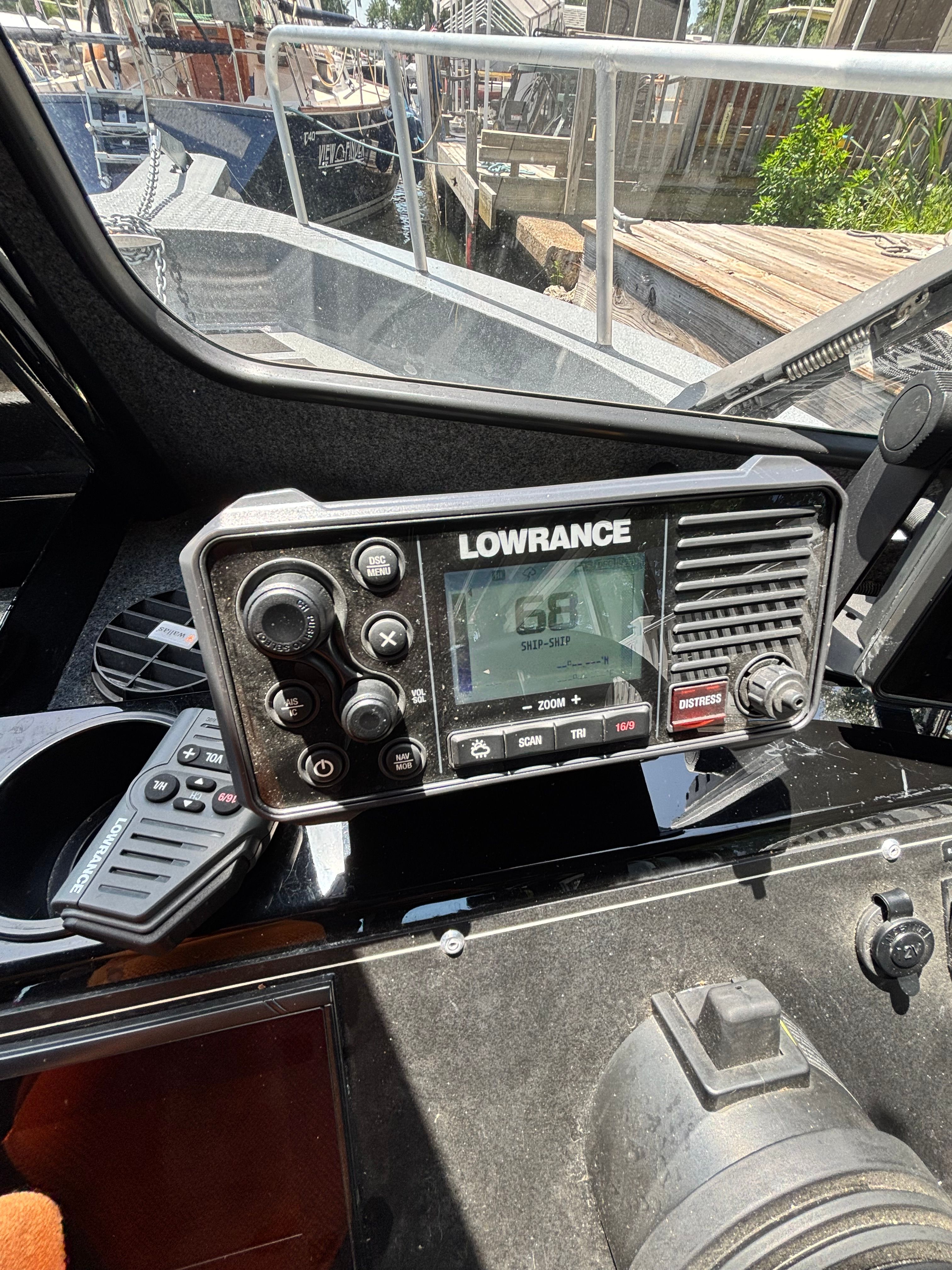 The image shows a navigation system on a boat, surrounded by controls and a window view.