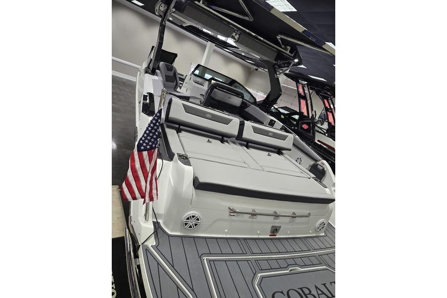 2026 Cobalt R31 boat with American flag, sleek design, and spacious seating.