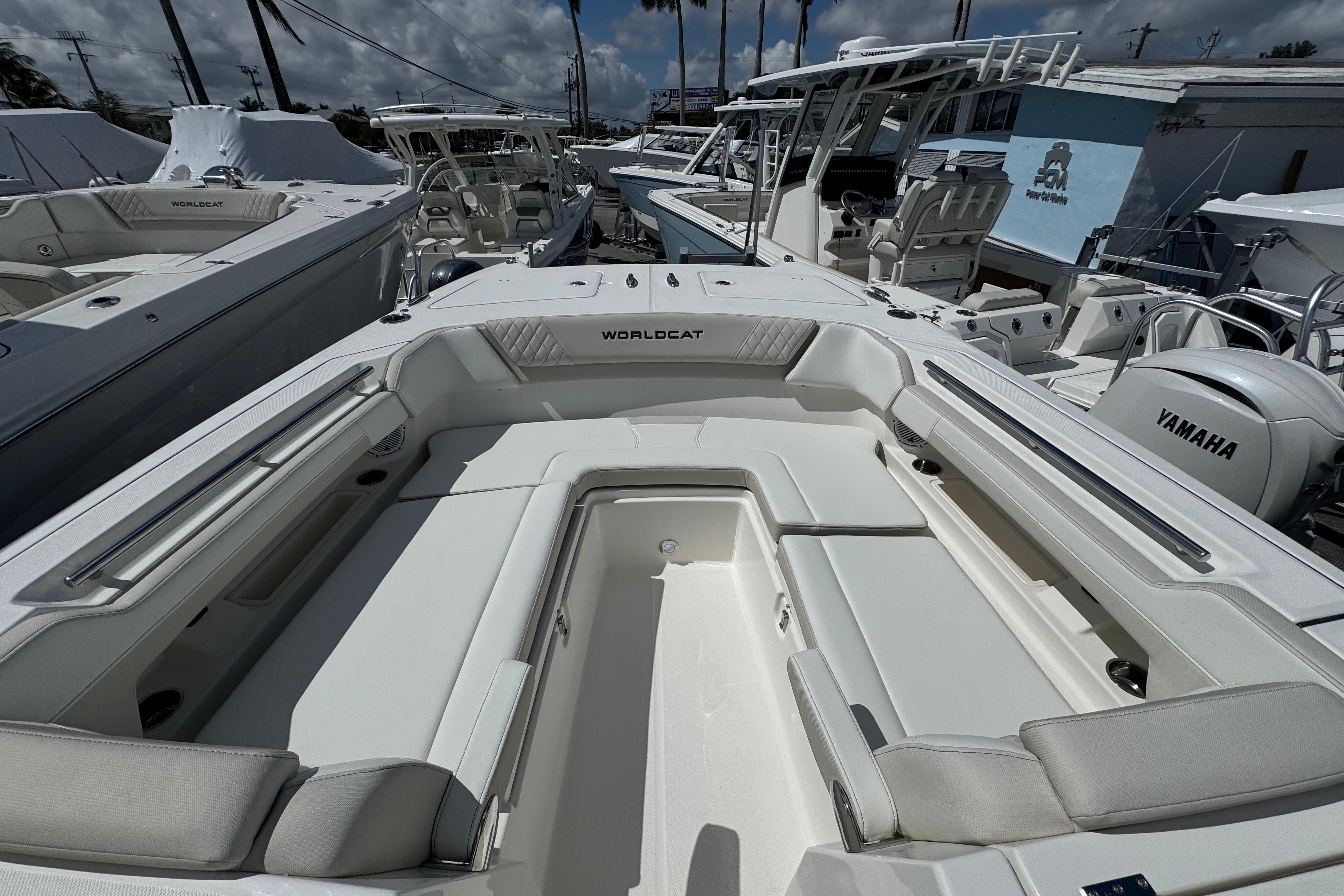 2026 World Cat 280 DC-X boat with spacious seating and Yamaha engines, docked under a cloudy sky.