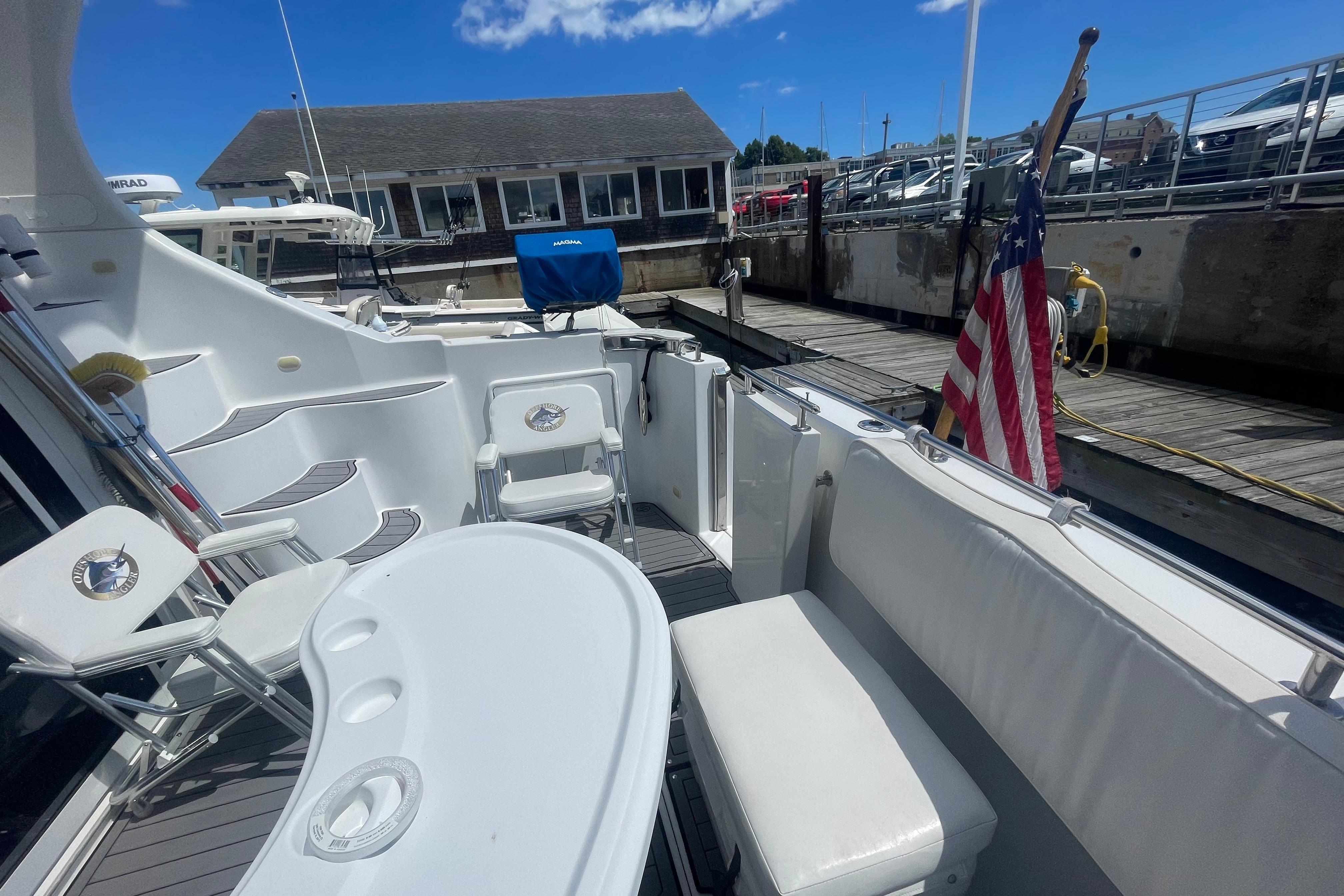 2002 Carver 410 Sport Sedan yacht deck with seating, docked at marina under blue sky.