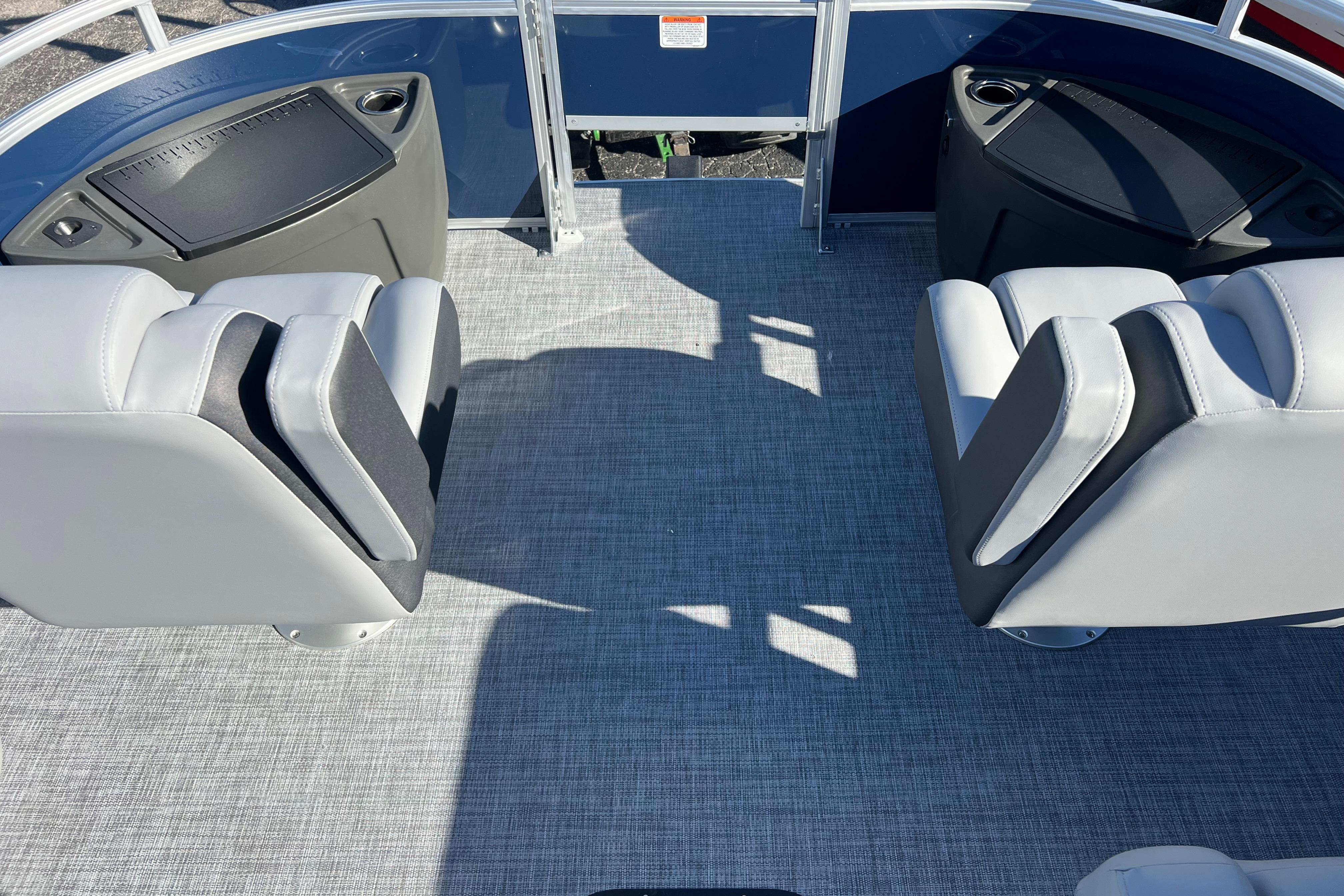 2026 Sun Tracker Sportfish 24 XP3 interior with gray seating and carpeted flooring.