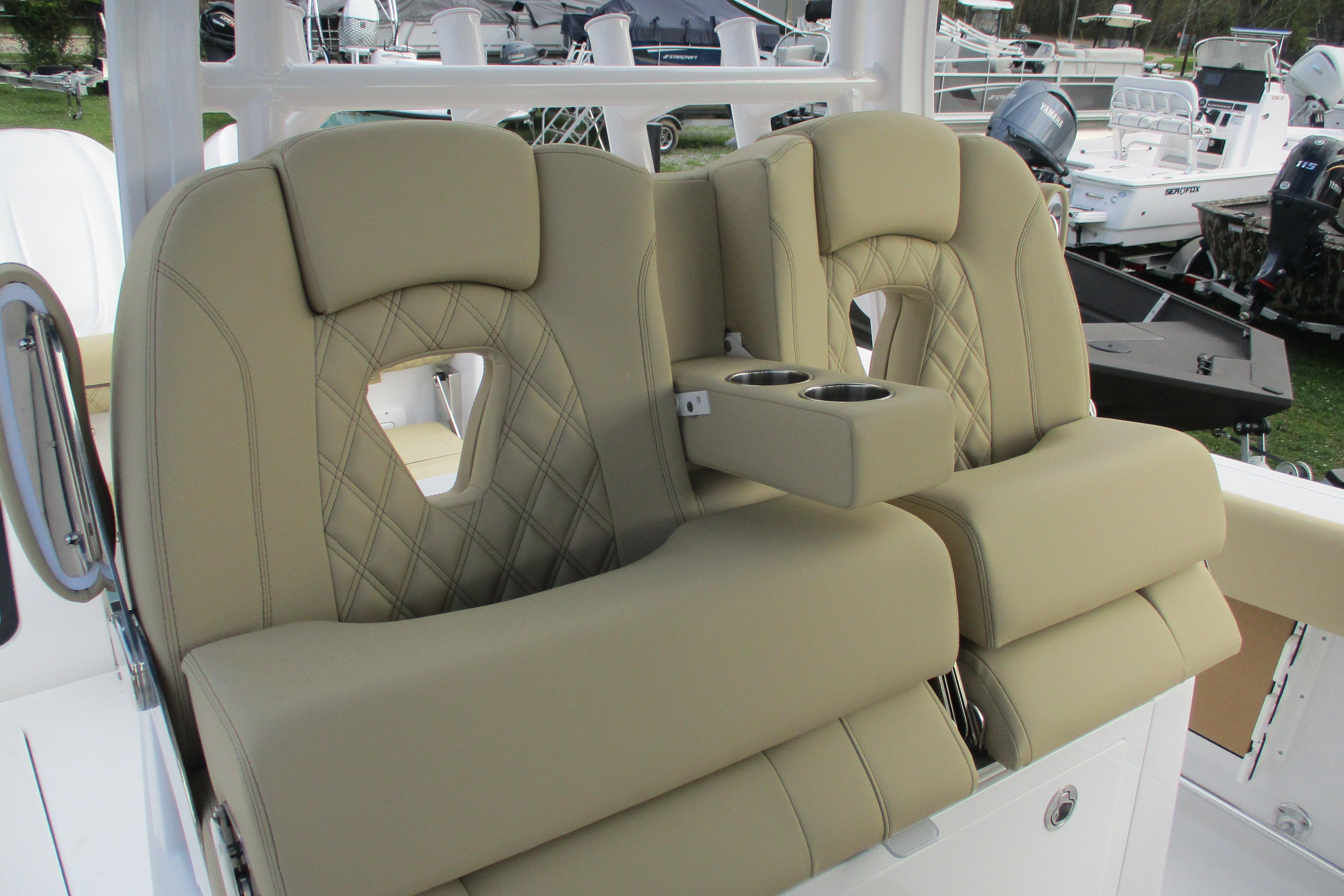 2026 Sportsman Open 302 Center Console boat seats with cup holders, featuring beige upholstery.