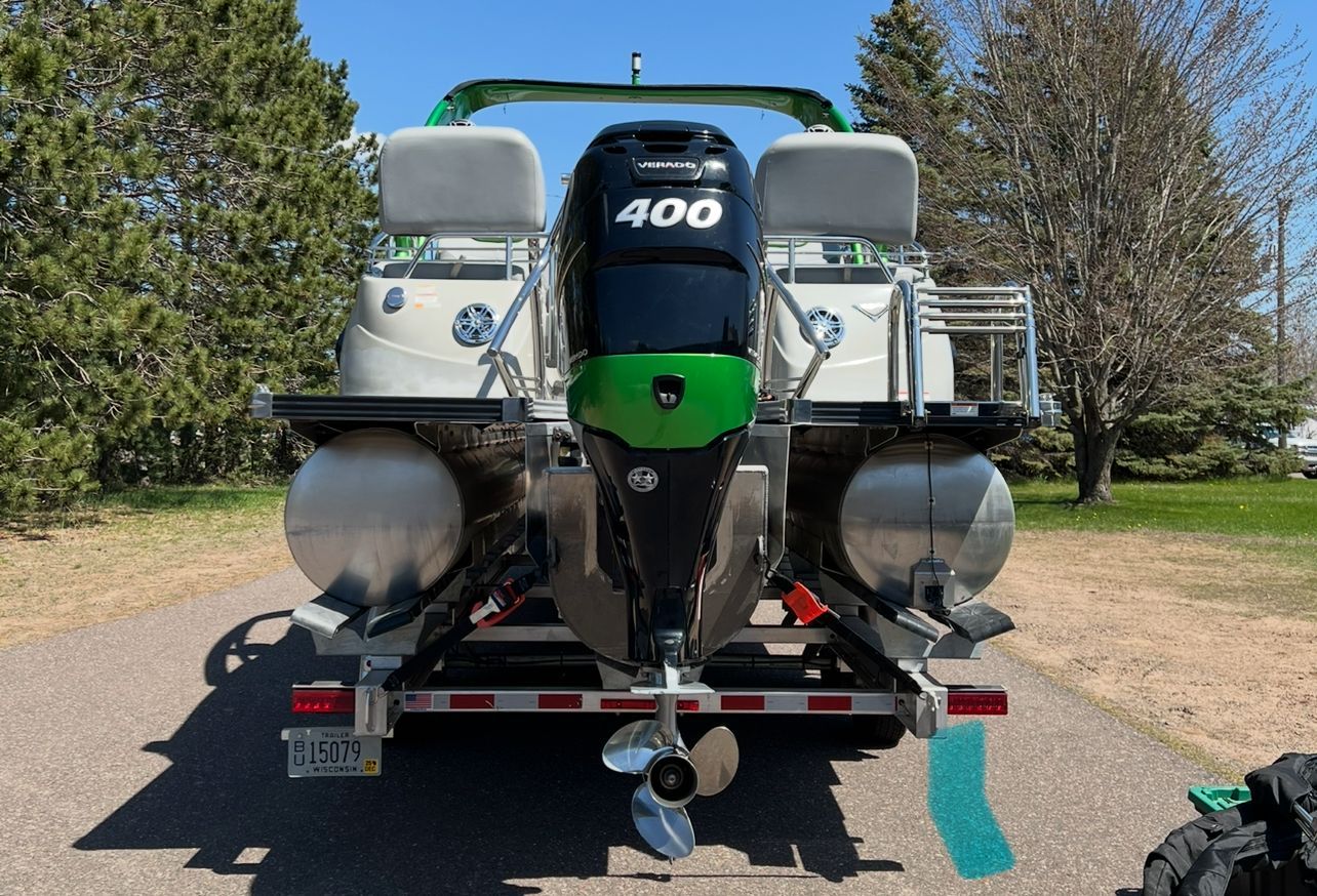 Rear view of a Manitou 27 X-Plode SHP pontoon boat with a large outboard motor.