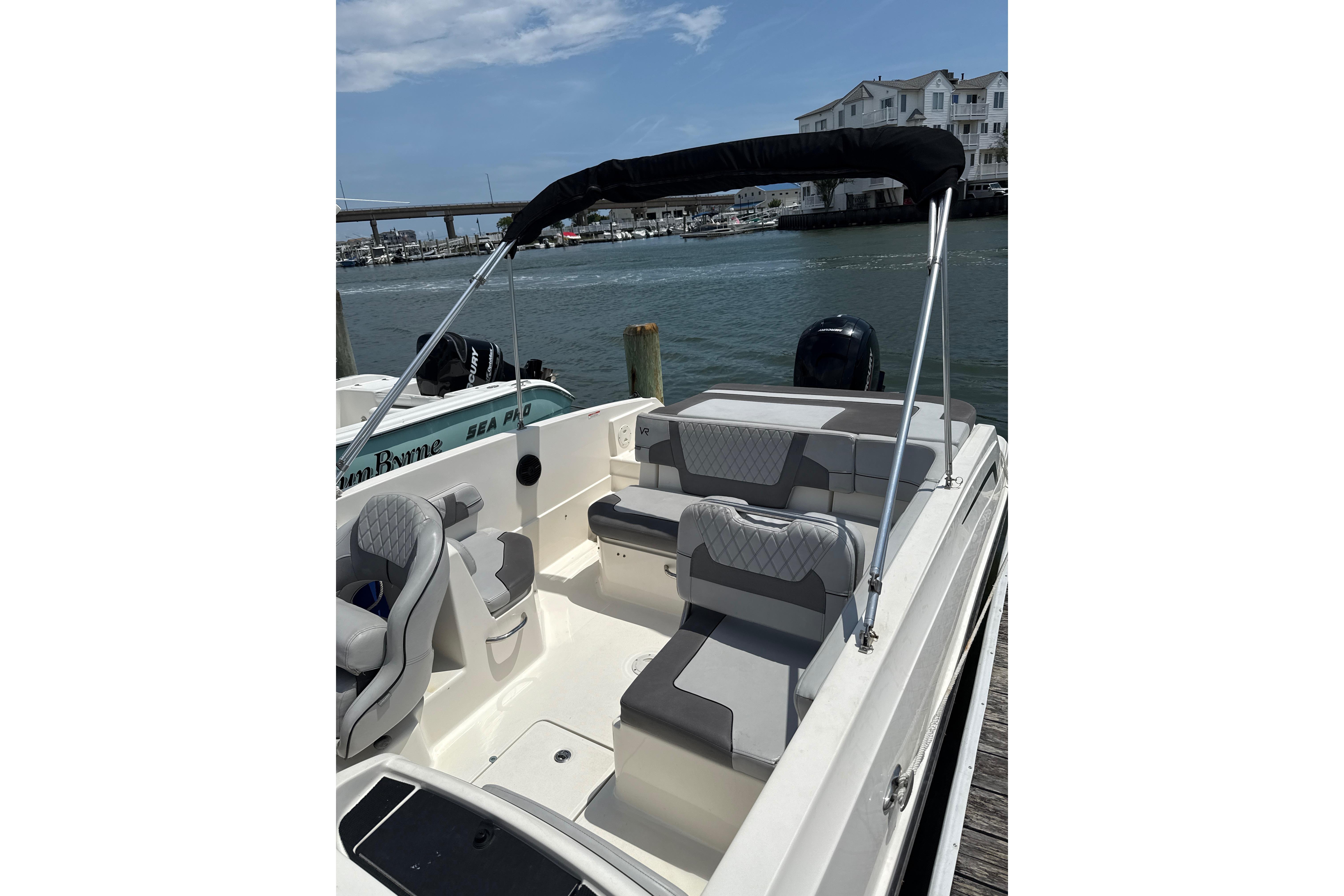 2023 Bayliner VR6 Bowrider OB with sleek seating, docked by waterfront homes.