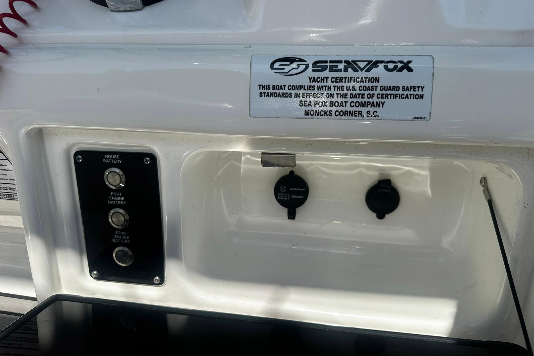 Control panel of a 2002 Sea Fox 228 Commander boat with battery switches and certification label.