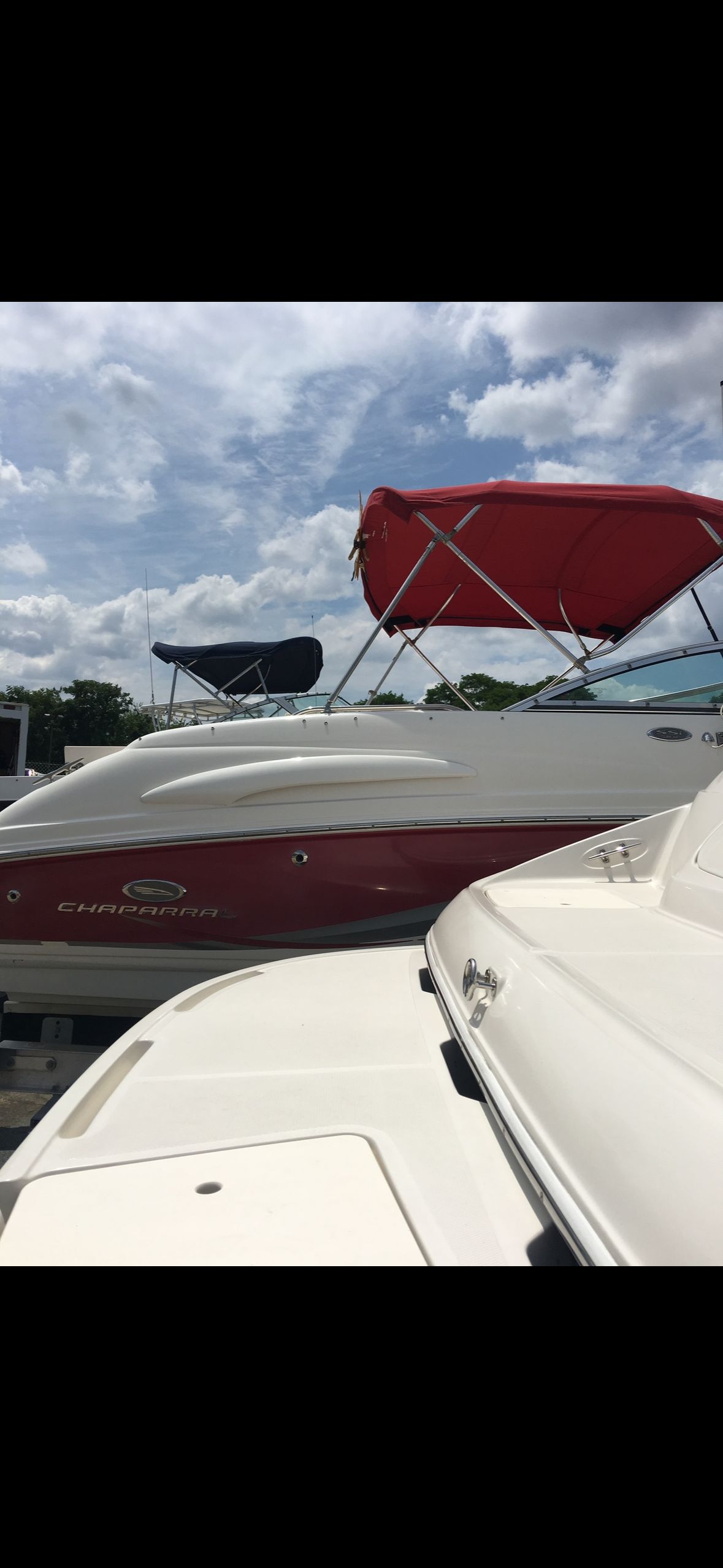 A 2006 Chaparral 235 SSi boat with a red hull and red sunshade.