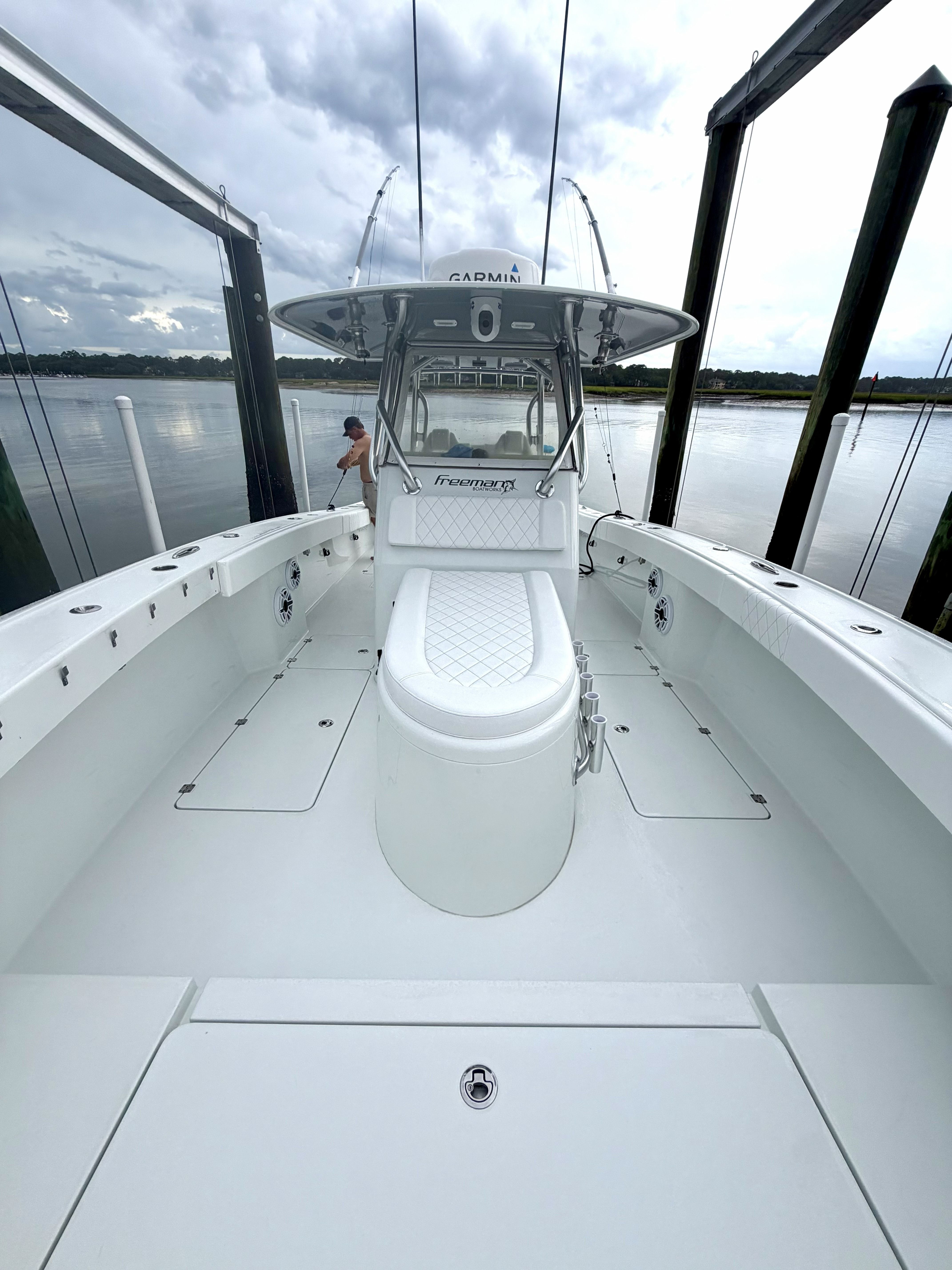 A 2018 Freeman 34VH boat with a spacious deck and modern helm, sitting on calm water.