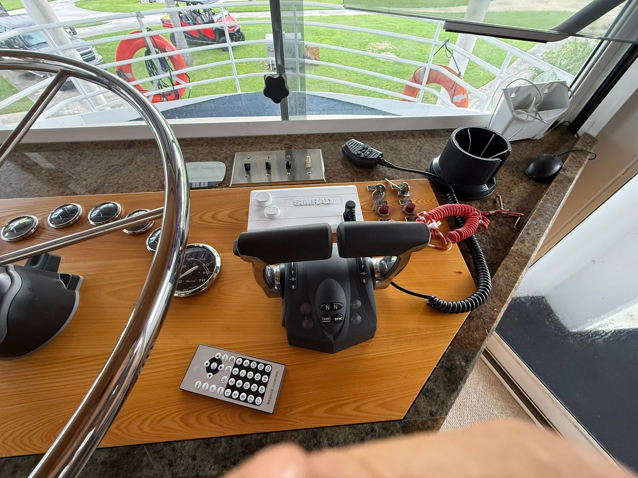 The image shows a boat's helm with various controls and a steering wheel.